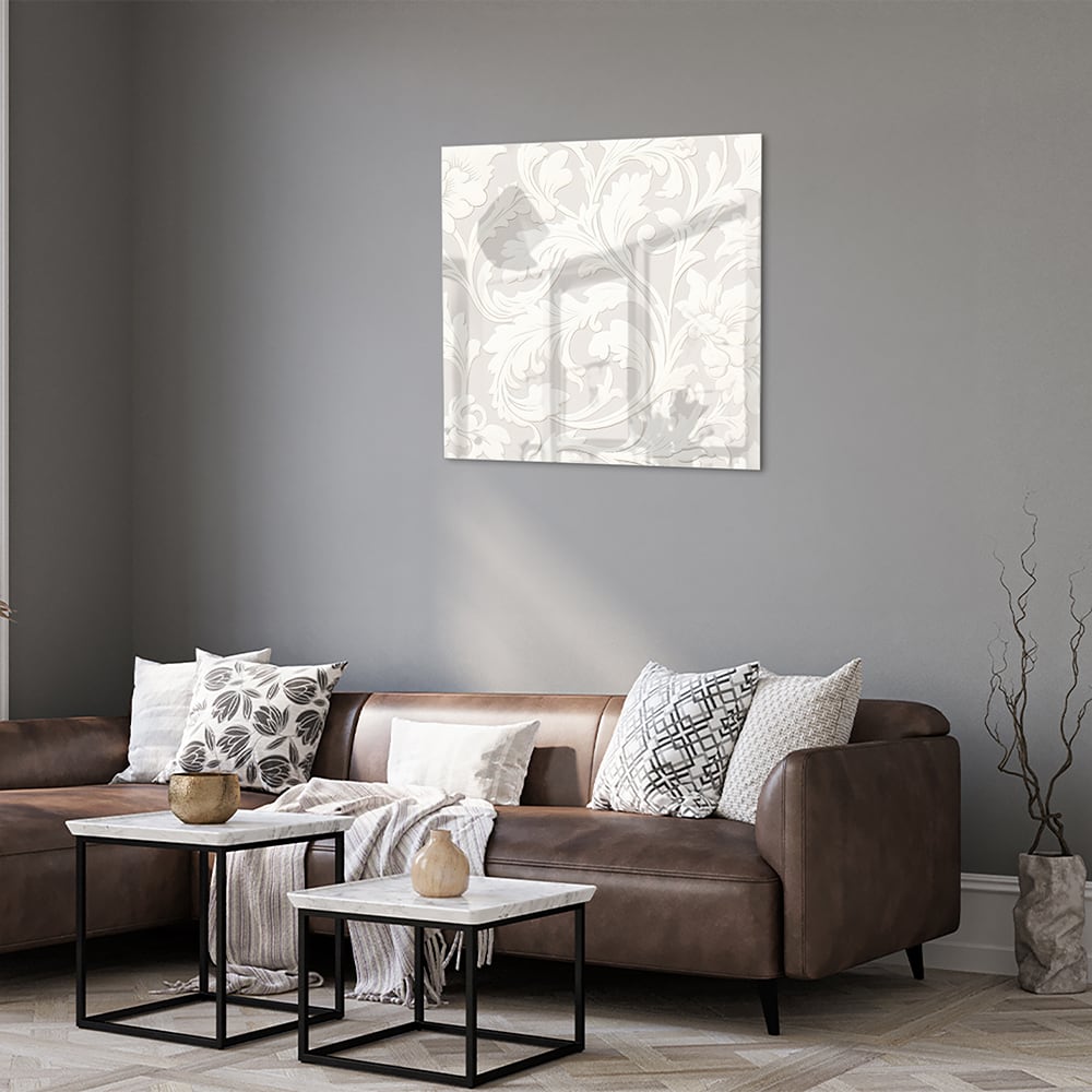 Glazen schilderij met subtiel bloemmotief aan de muur in een lichte woonkamer