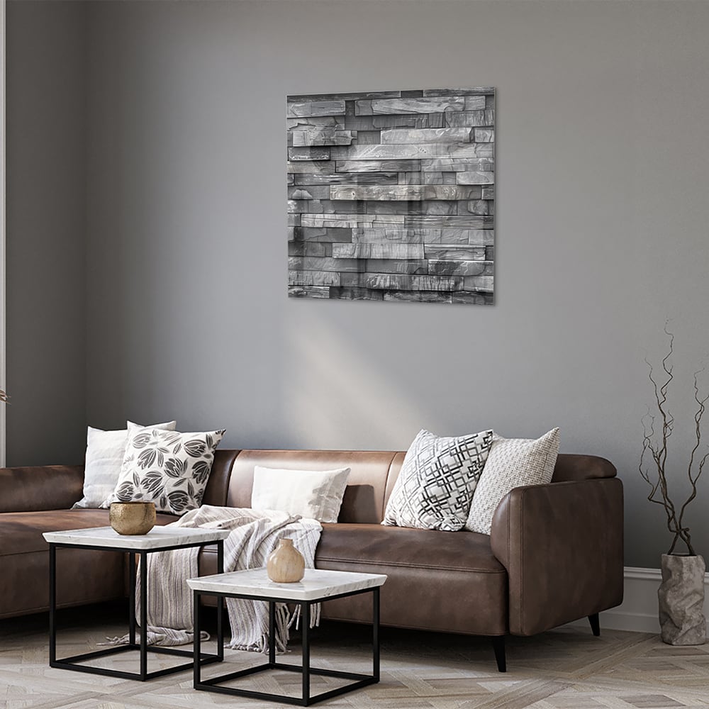 Moderne glazen schilderij met grijze texturen aan een lichte muur.