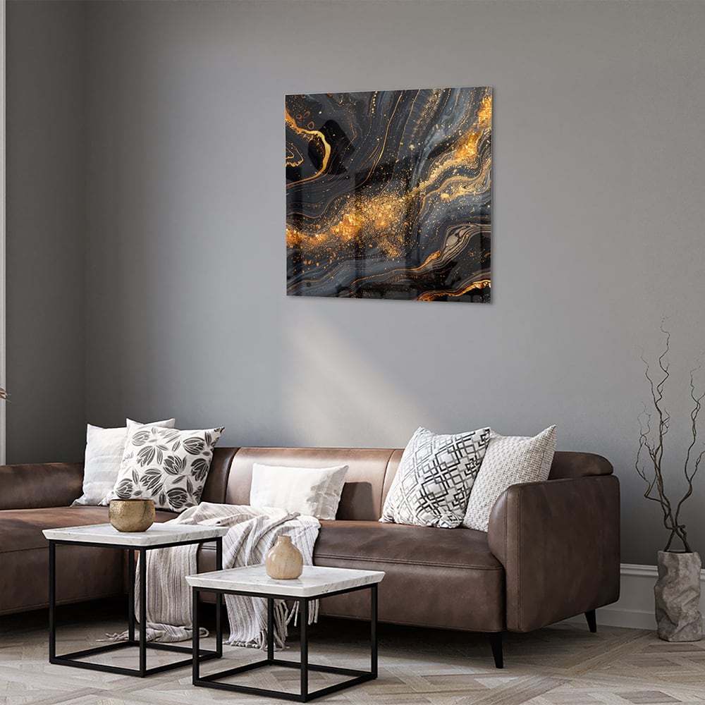 Glas schilderij met een zwart en gouden marmerdesign aan de muur in een moderne woonkamer