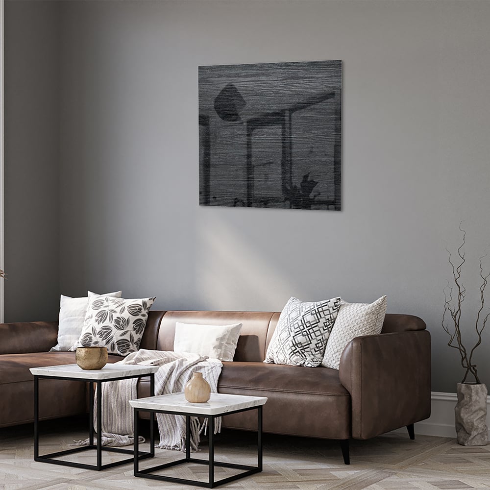 Stijlvol zwart glazen schilderij aan een wand in een moderne woonkamer.