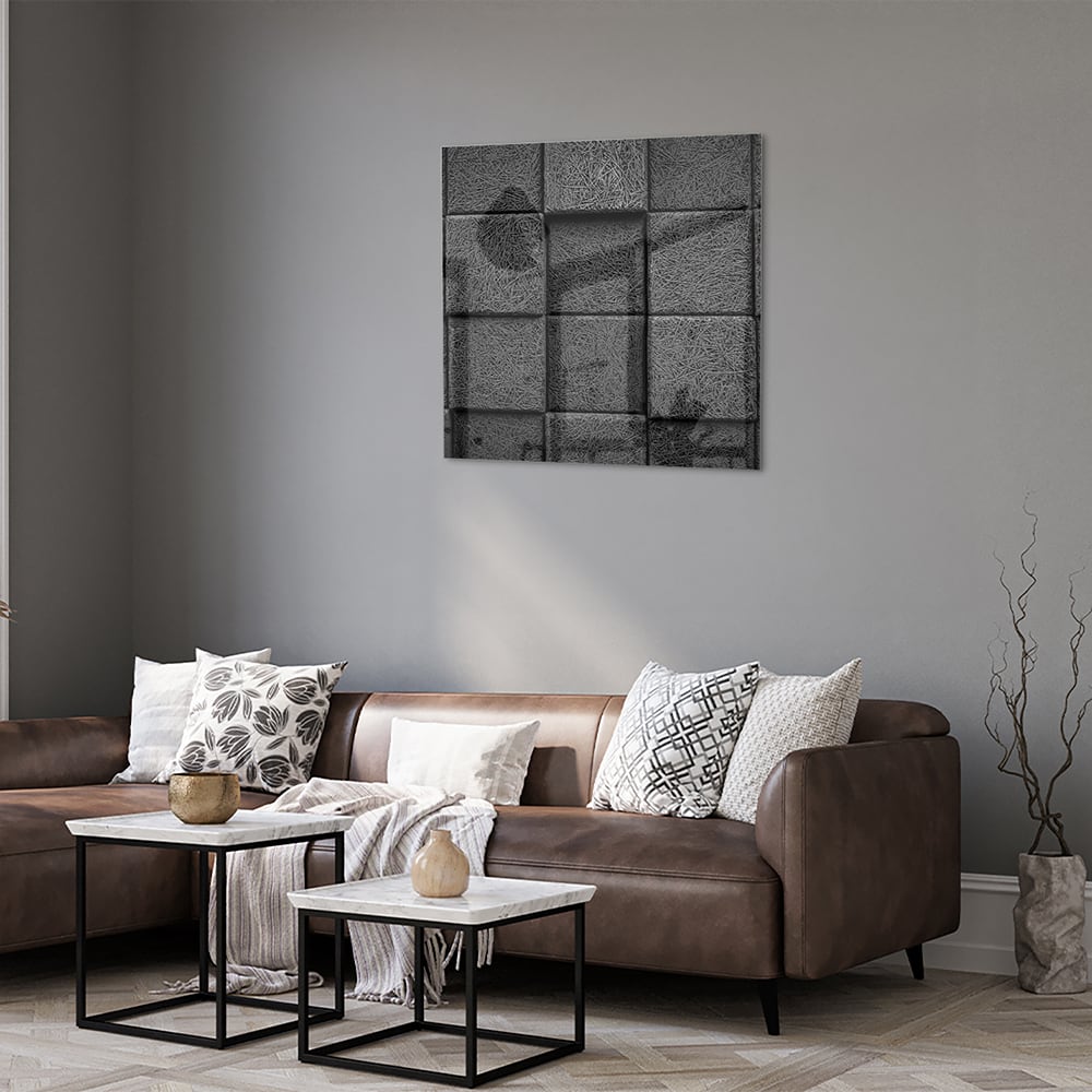 Abstract donker glazen schilderij aan een witte muur in een moderne woonkamer