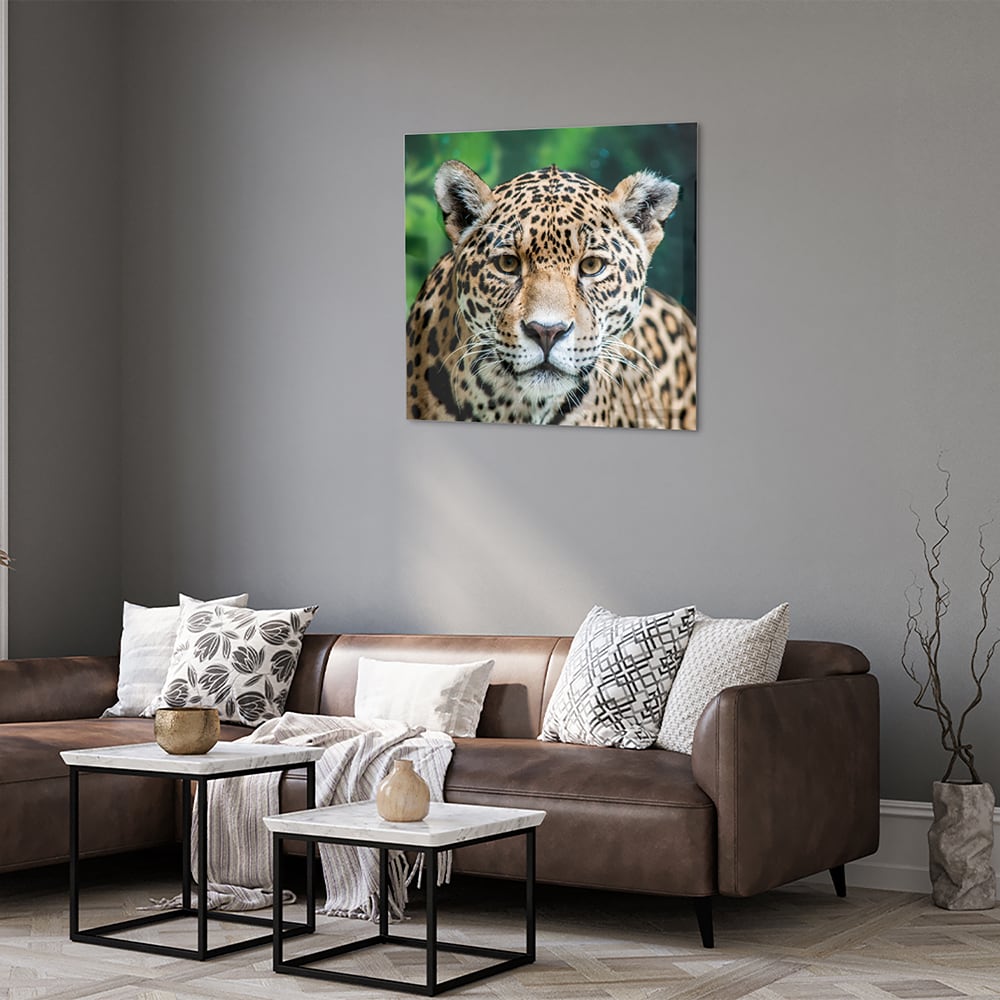 Glazen schilderij van een jaguar dat aan de muur hangt in een moderne woonkamer.