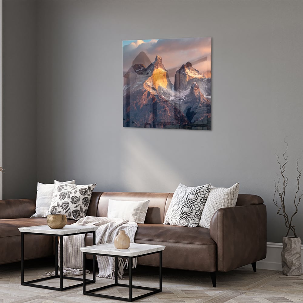 Glazen schilderij met berglandschap aan de muur in een moderne woonkamer