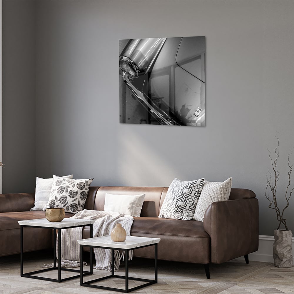 Glazen schilderij met abstracte vormen aan de muur in een stijlvolle kamer.