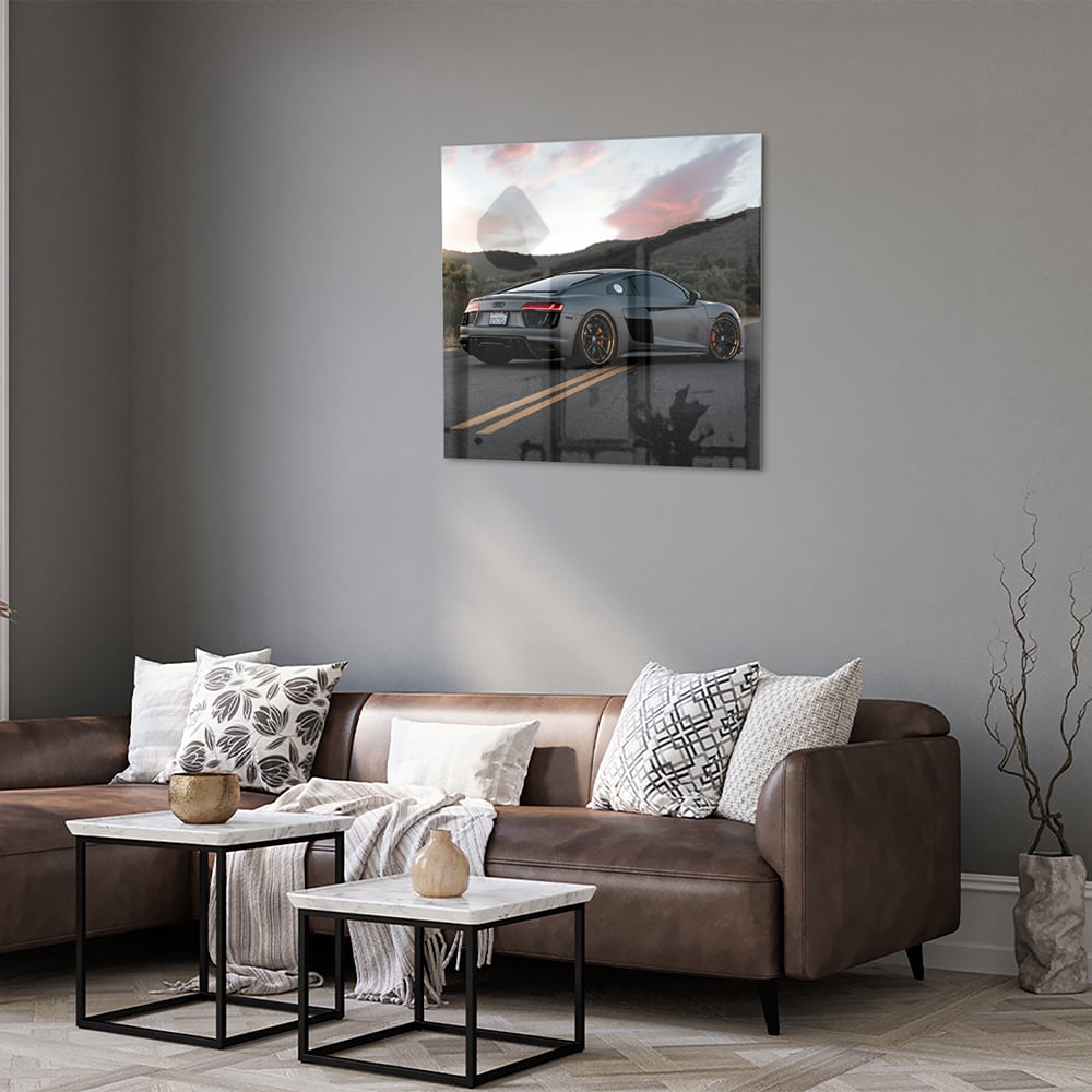 Glazen schilderij van een sportwagen afgebeeld in de natuur met bergen op de achtergrond.
