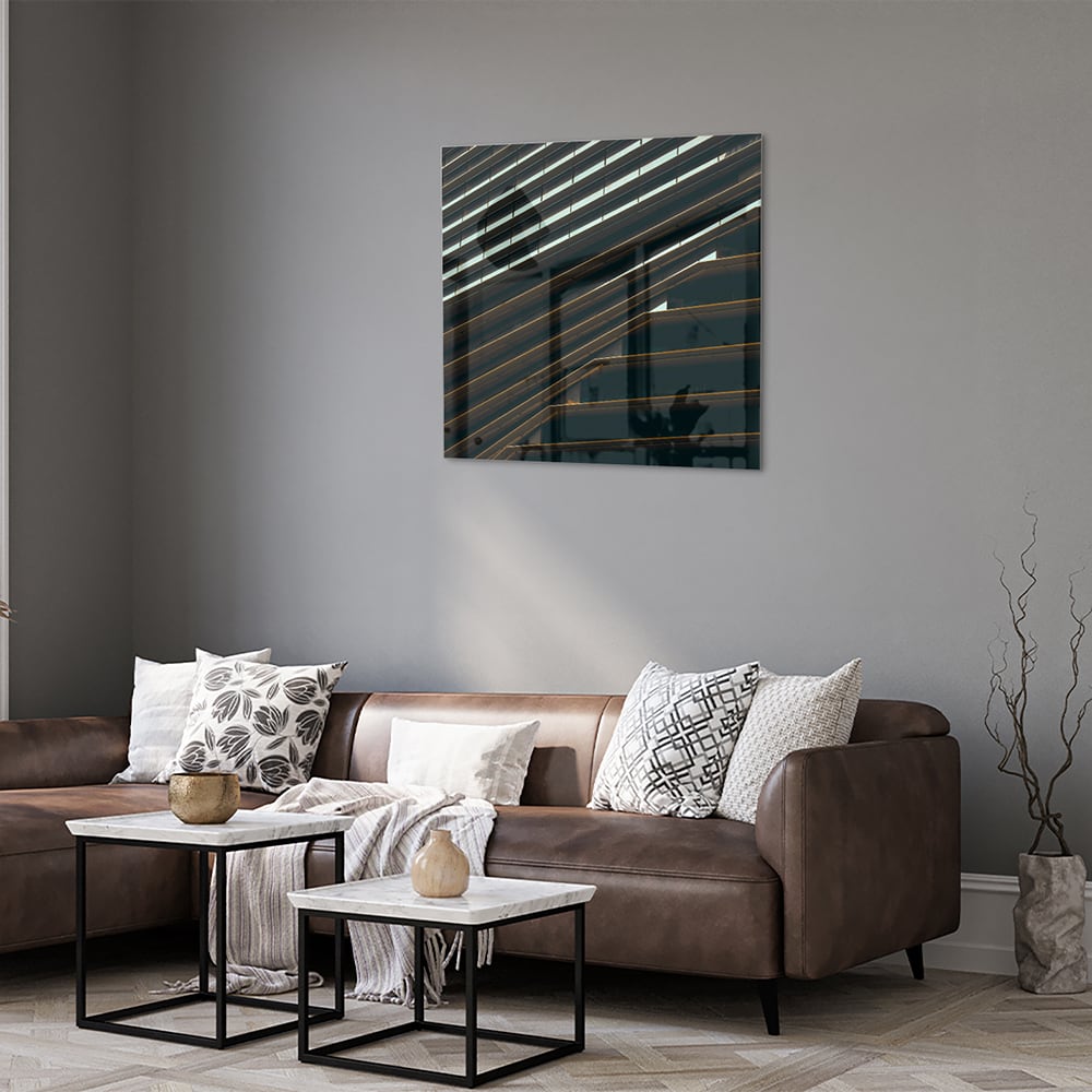 Stijlvol glazen schilderij met zwarte lijnen aan de muur in een moderne woonkamer.