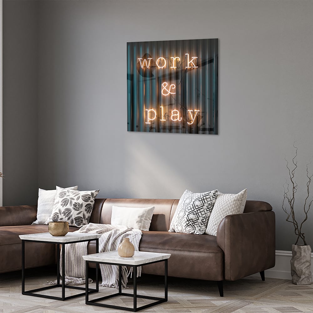 Glazen schilderij met de woorden 'Work & Play' in sfeervolle verlichting.