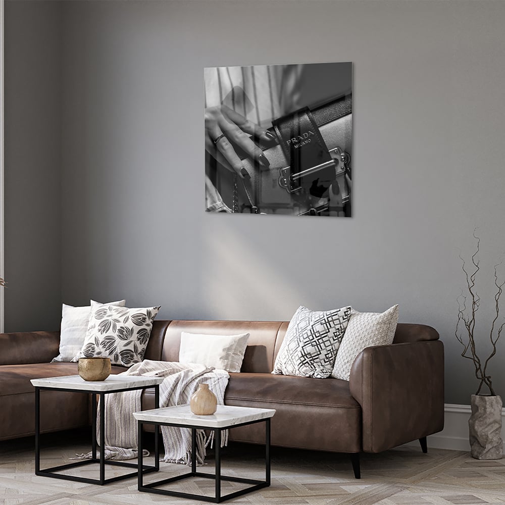 Glazen schilderij met close-up van luxe accessoires op een wand.