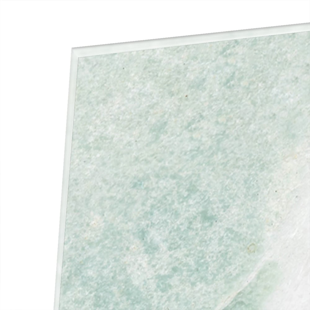 Abstract groen glazen schilderij aan de muur boven een houten meubel.