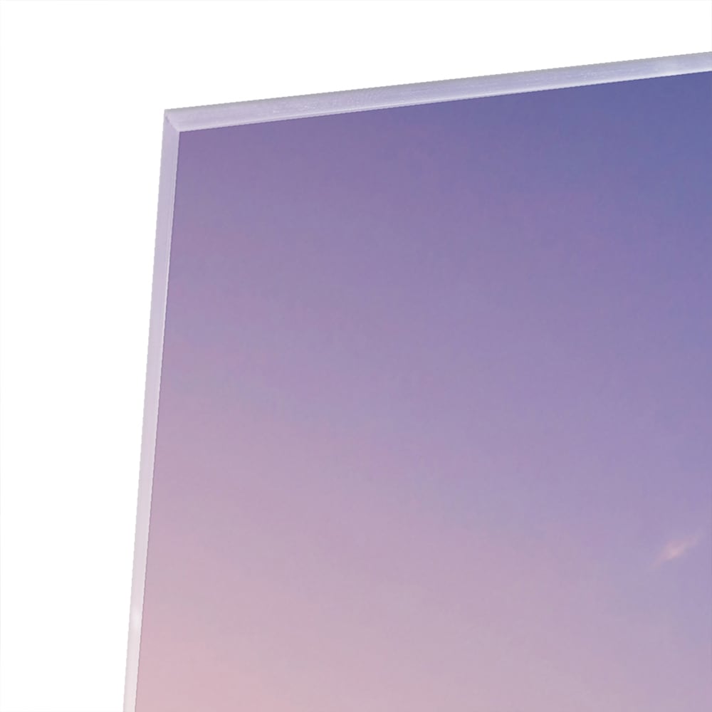 Een glazen schilderij van de Eiffeltoren bij zonsondergang, met warme kleuren.