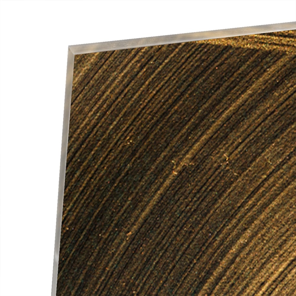 Glazen schilderij met gouden patronen aan de muur boven een houten meubel.