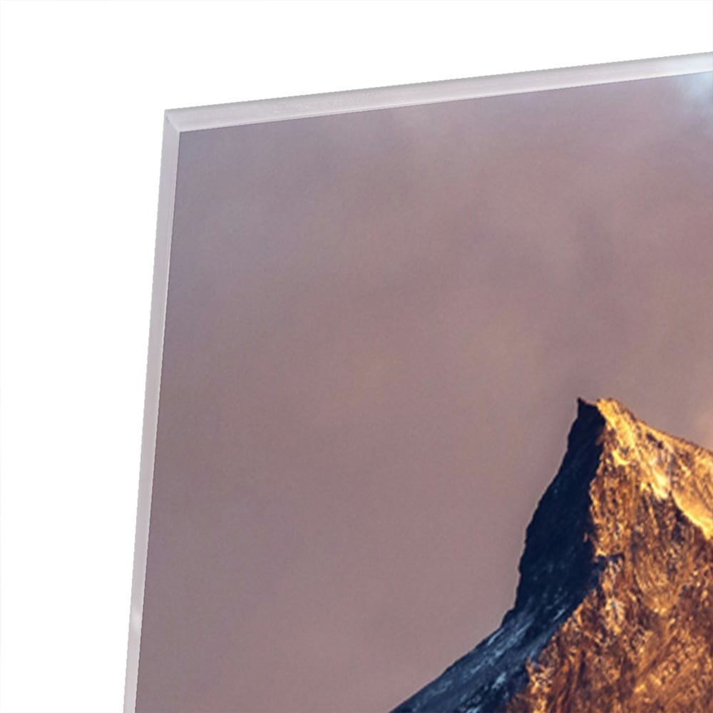 Een glazen schilderij van majestueuze bergen met gouden ochtendlicht