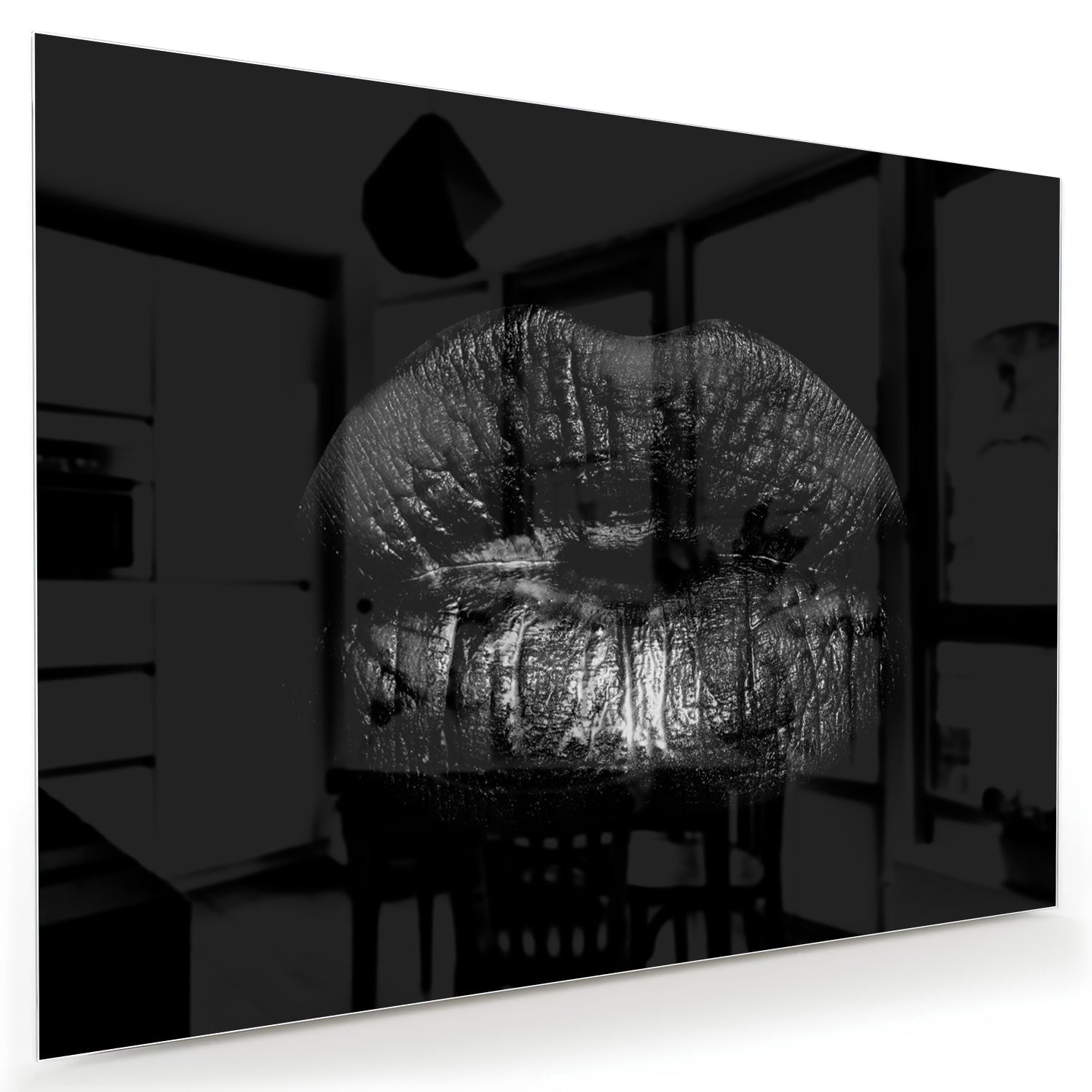 Zwart glazen schilderij met een artistieke lippenprint aan de muur.