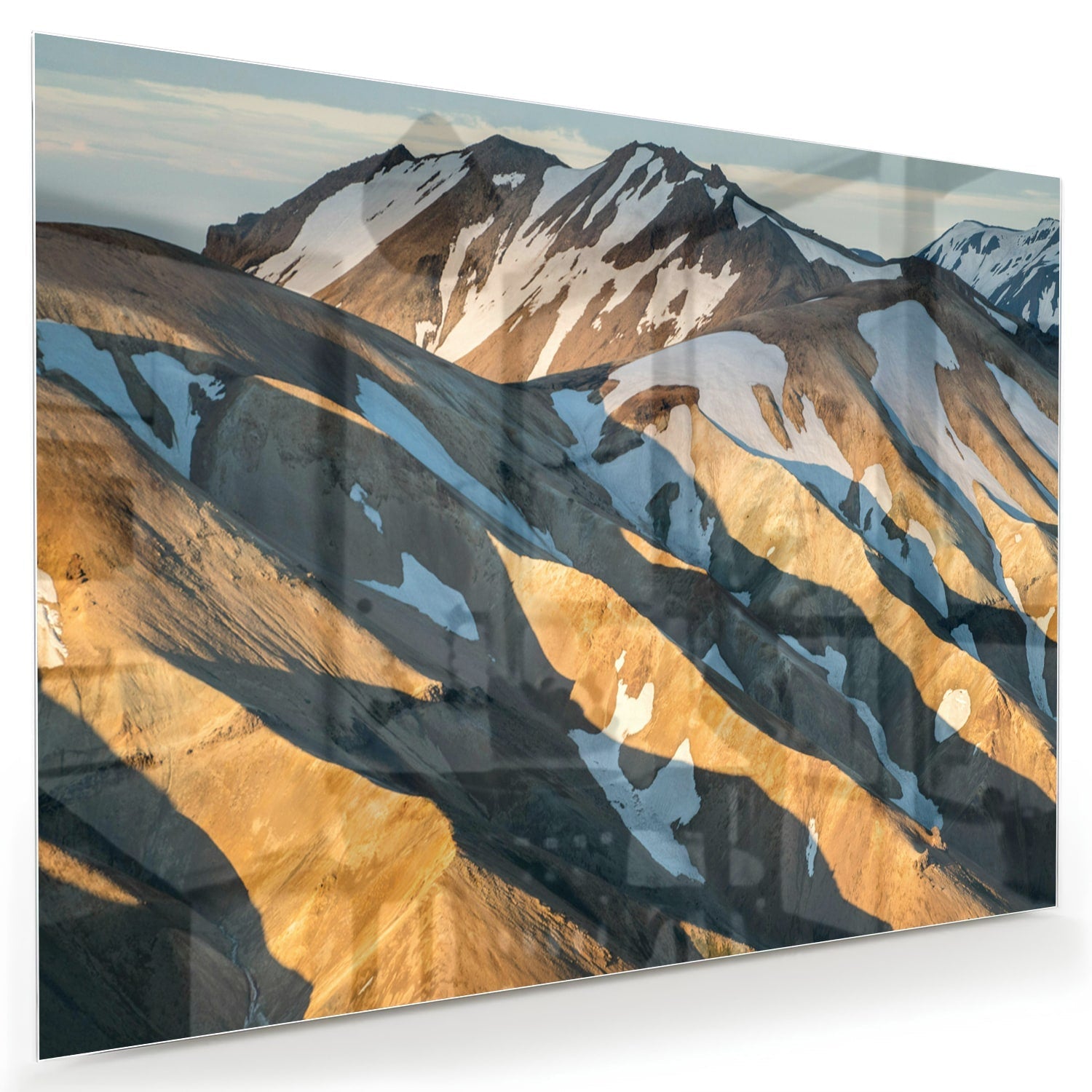 Glazen schilderij van bergen in blauw en goud, hanging in een stijlvolle kamer.