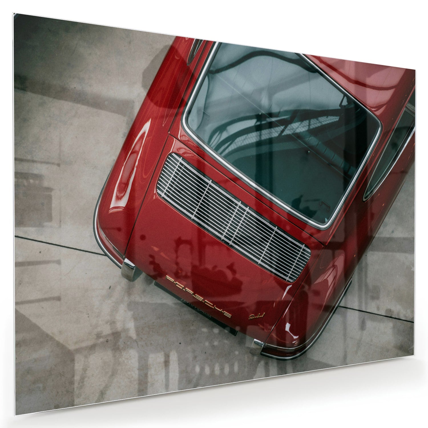 Glazen schilderij van een bovenaf gezien rode auto op een muur.