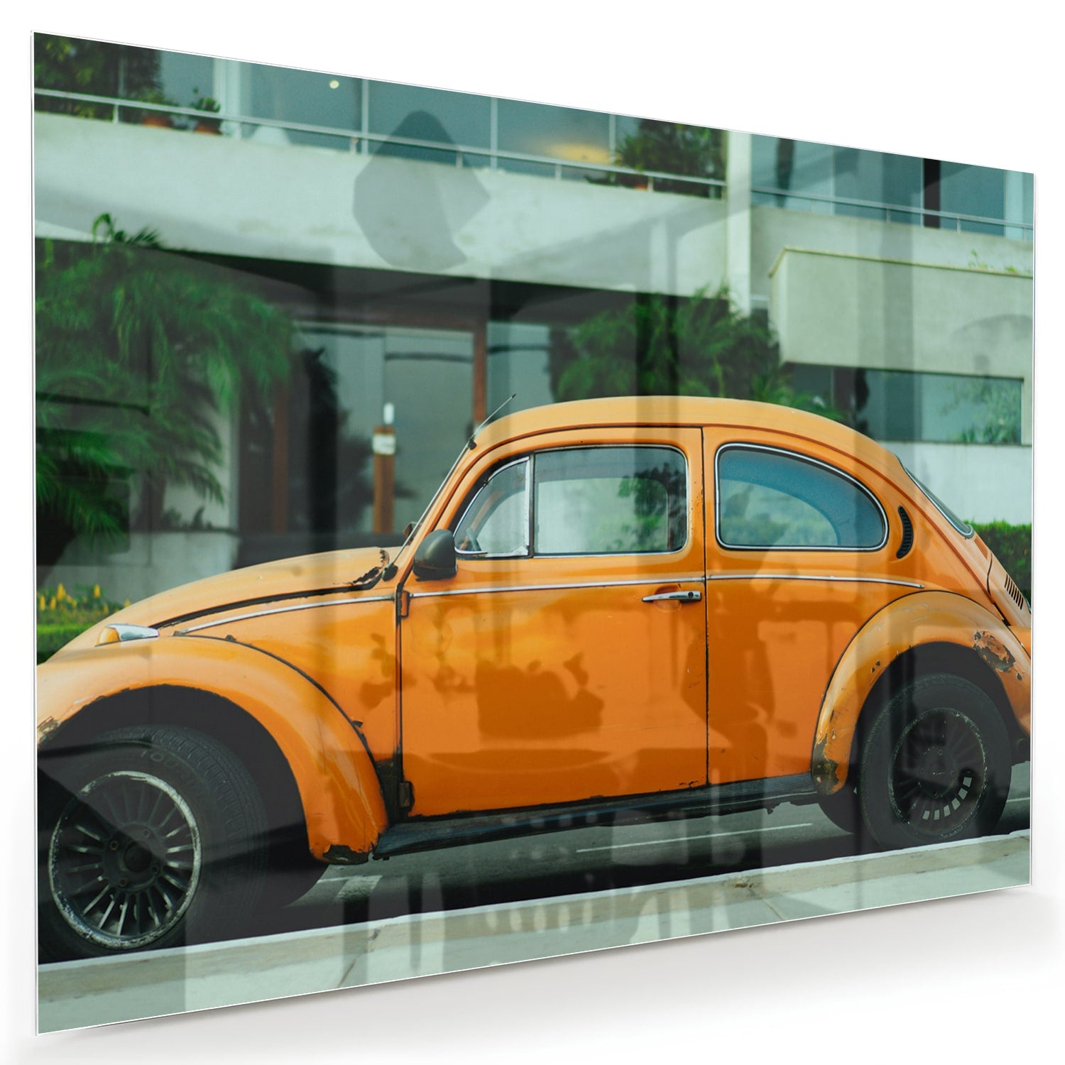 Glazen schilderij van een oranje Volkswagen Kever op een muur