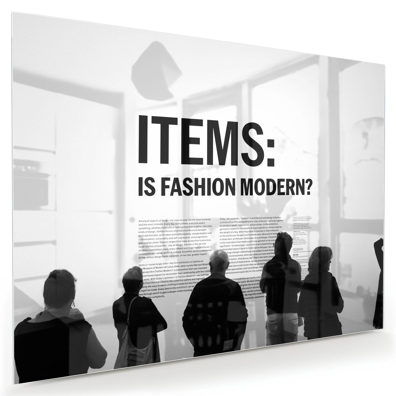 Glazen schilderij met de tekst 'ITEMS: IS FASHION MODERN?', stijlvol gepresenteerd boven een houten meubel.