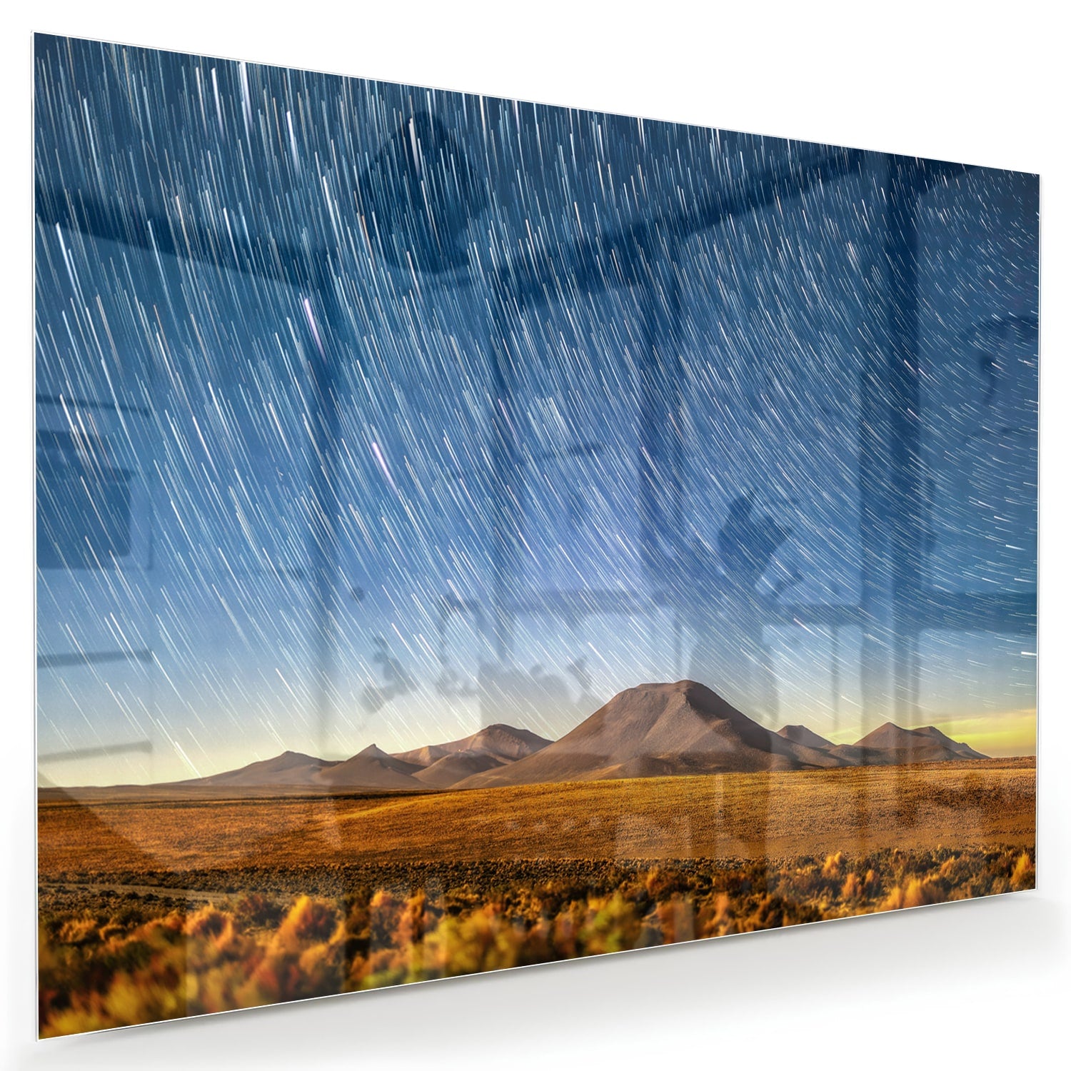 Glazen schilderij met sterrenhemel boven bergen, hangend aan de muur.
