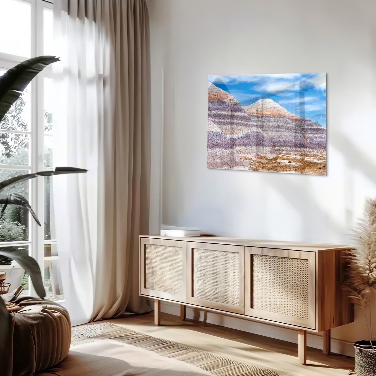 Glazen schilderij van bergen met een blauwe lucht in een moderne woonkamer.