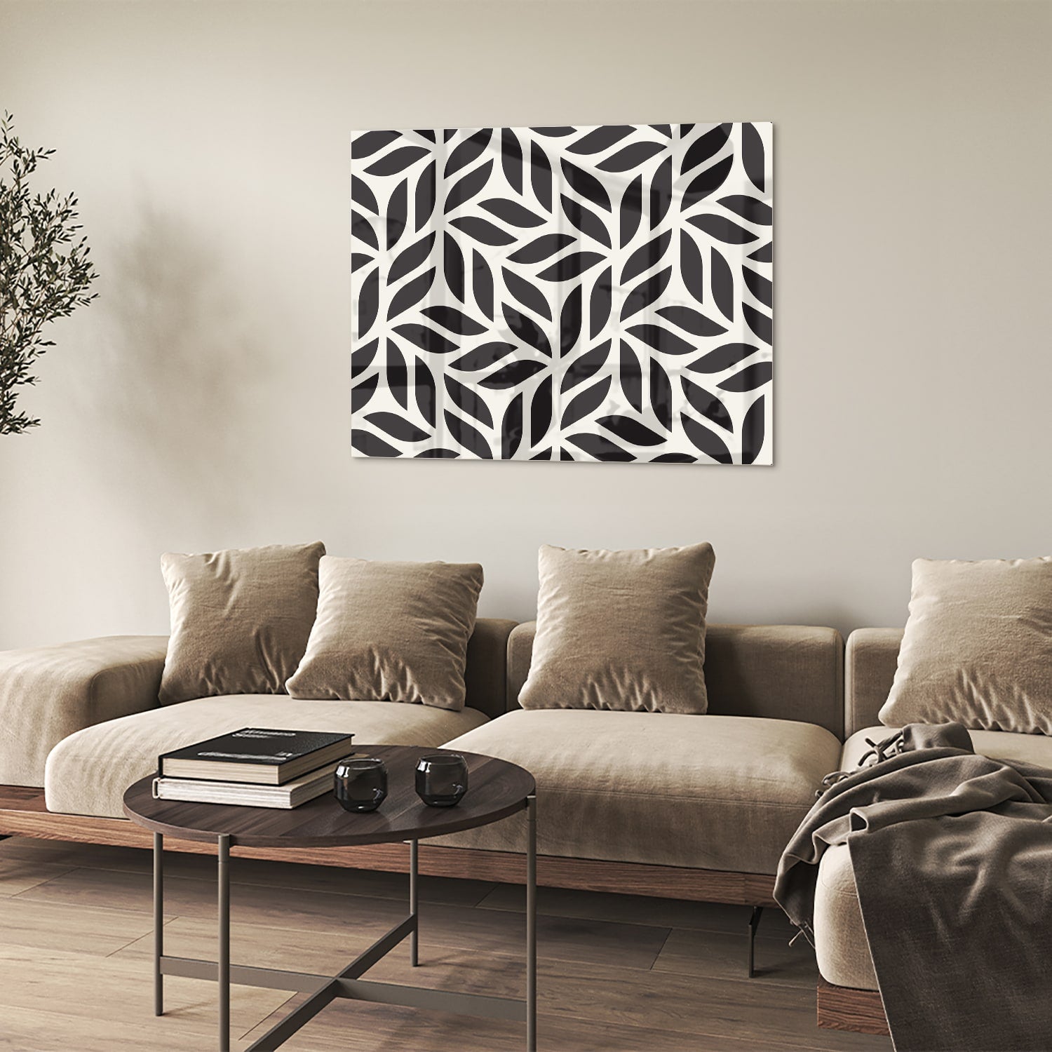 Zwart-wit glazen schilderij met bladerenpatroon aan de muur in een moderne woonkamer.