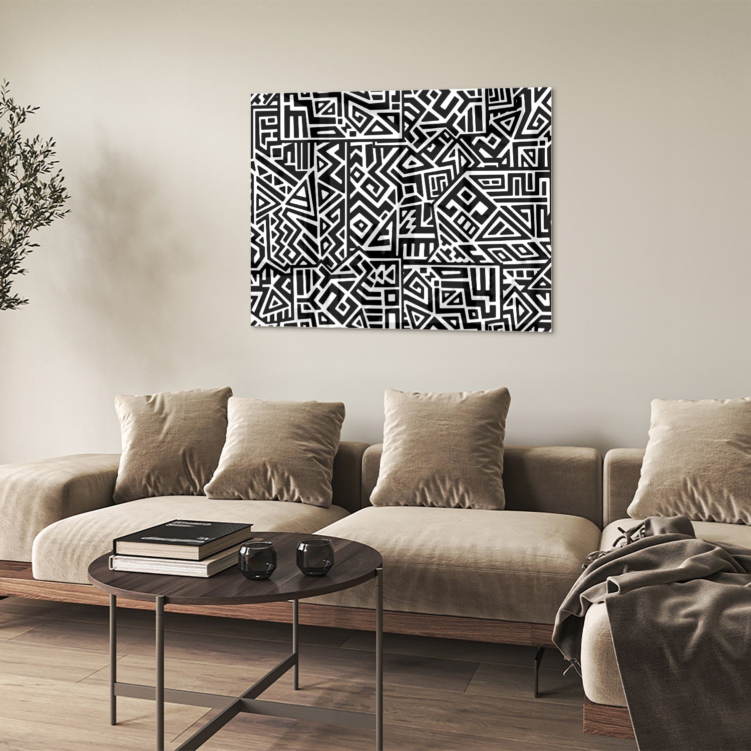 Zwart-wit glazen schilderij met abstract patroon aan de muur in een moderne woonkamer.
