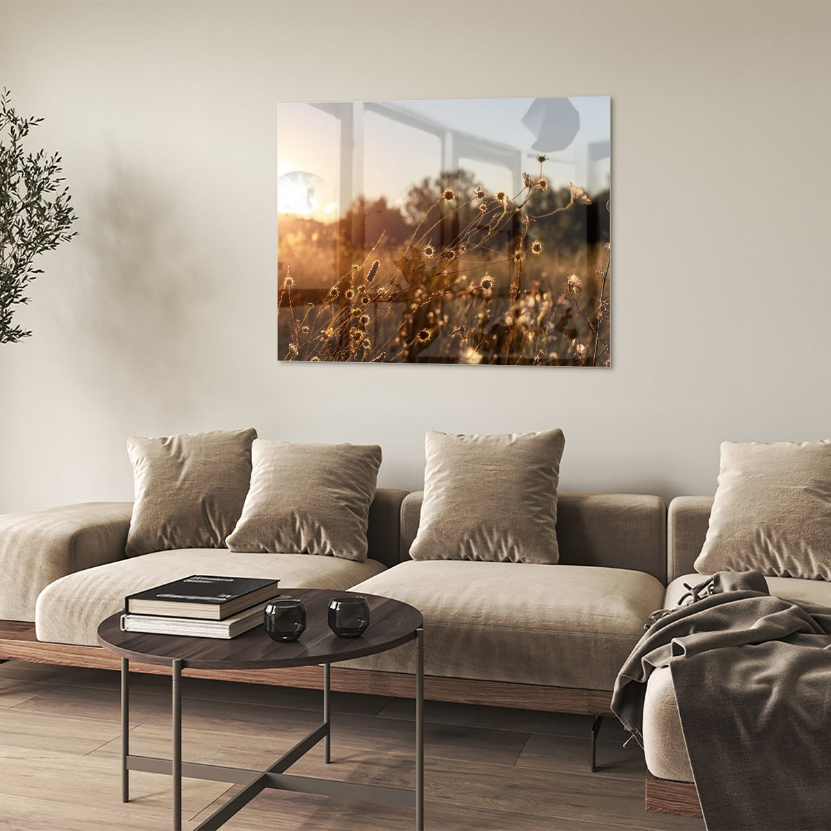 Glazen schilderij van een zonsondergang met bloeiende bloemen, hangend aan een witte muur.