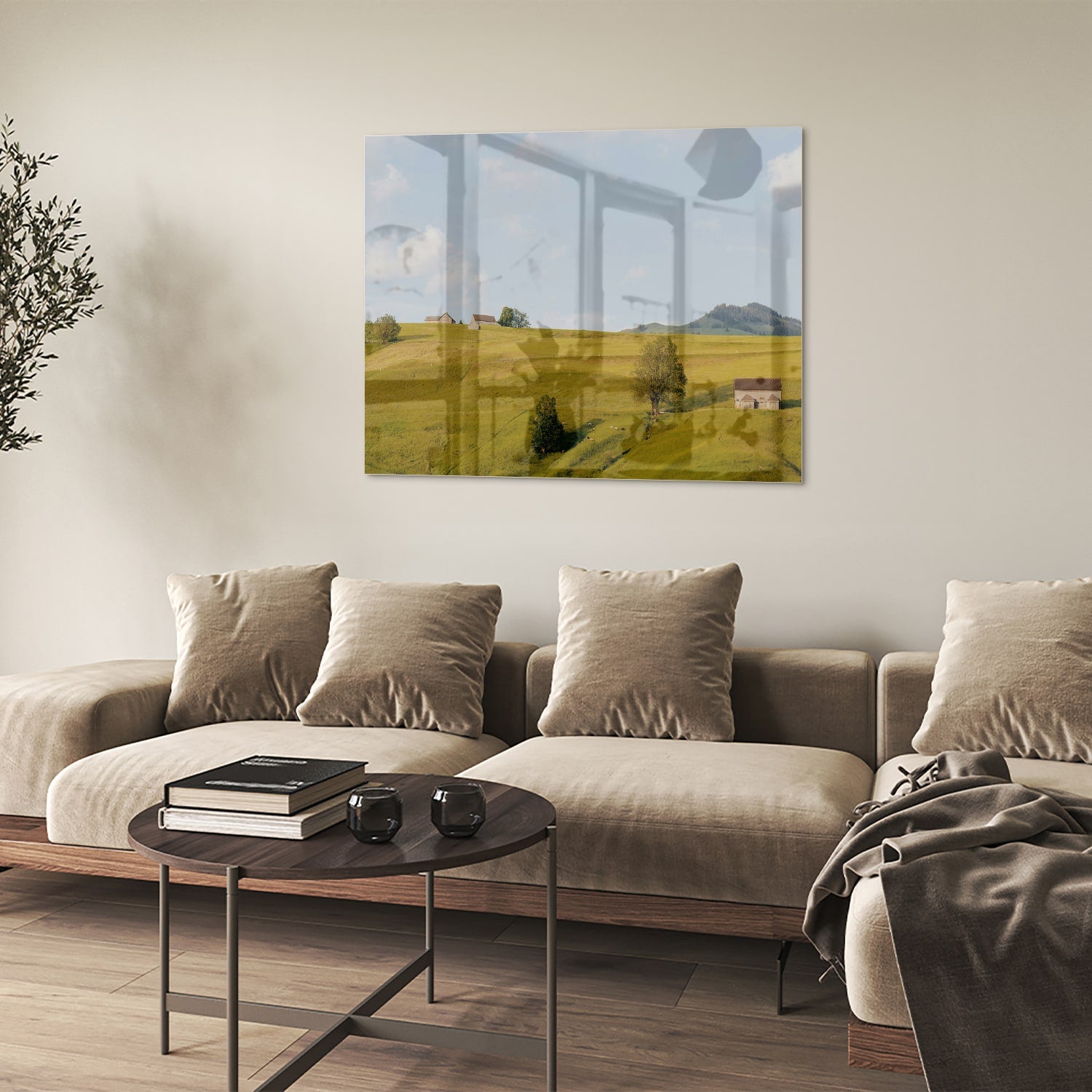 Glazen schilderij met groene heuvels en boerderijen op een witte muur.