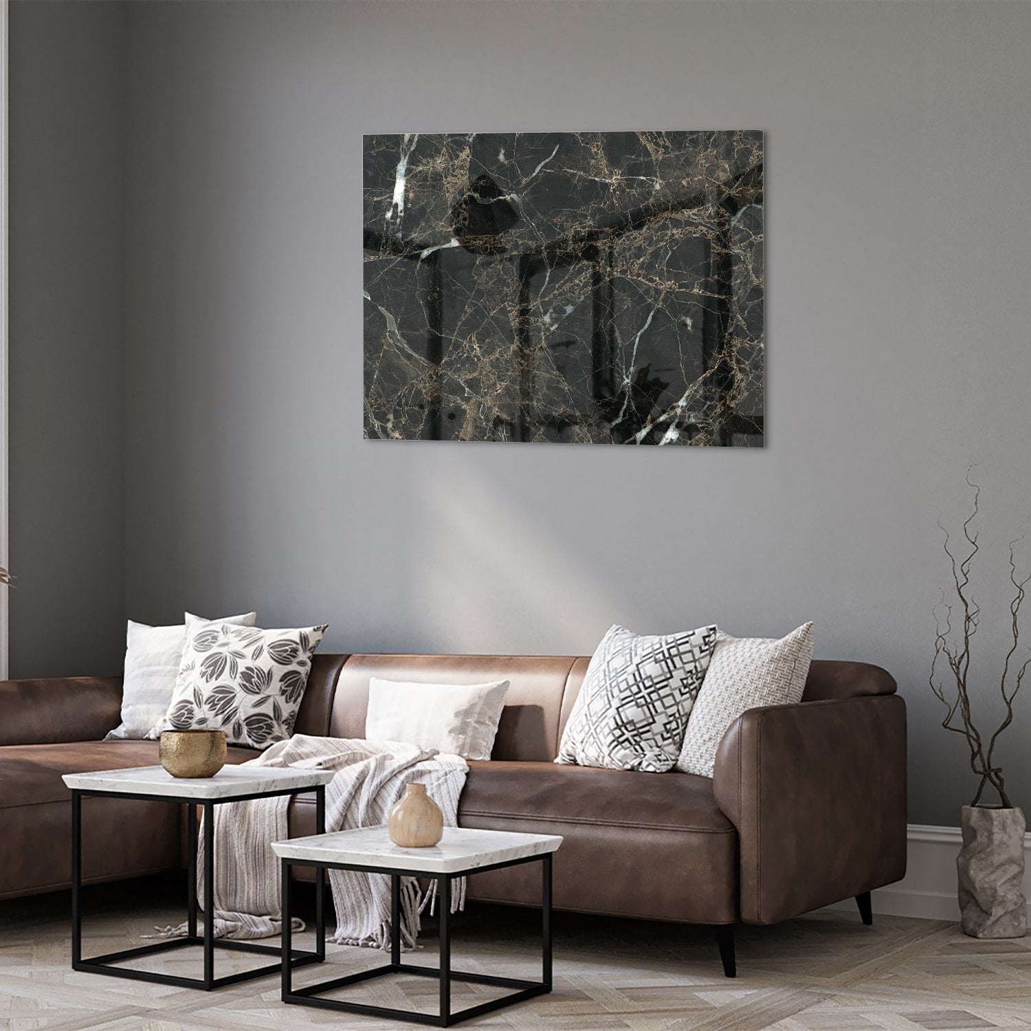 Glazen schilderij van zwart marmer met gouden aderen, hangt boven een moderne meubelstuk.