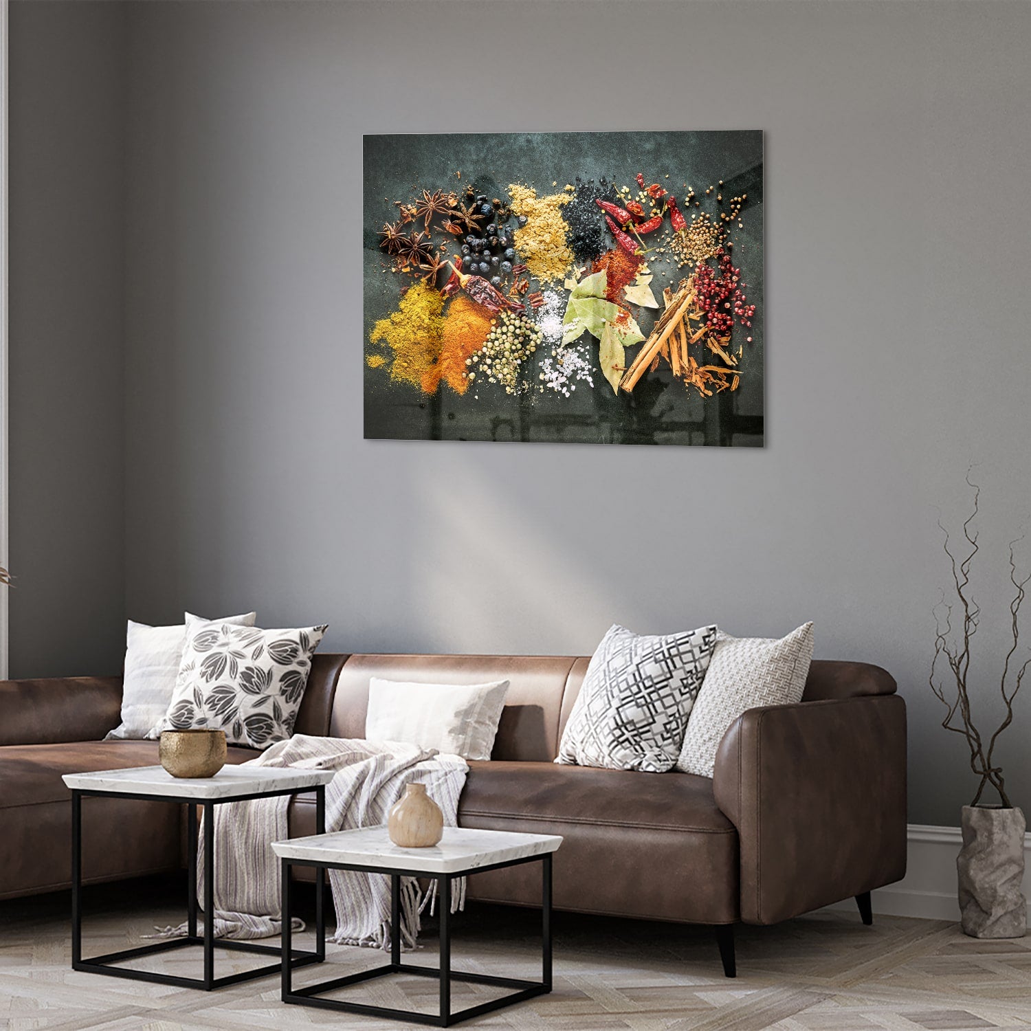 Glazen schilderij met een kleurrijke compositie van specerijen en bladeren in een moderne woonkamer.
