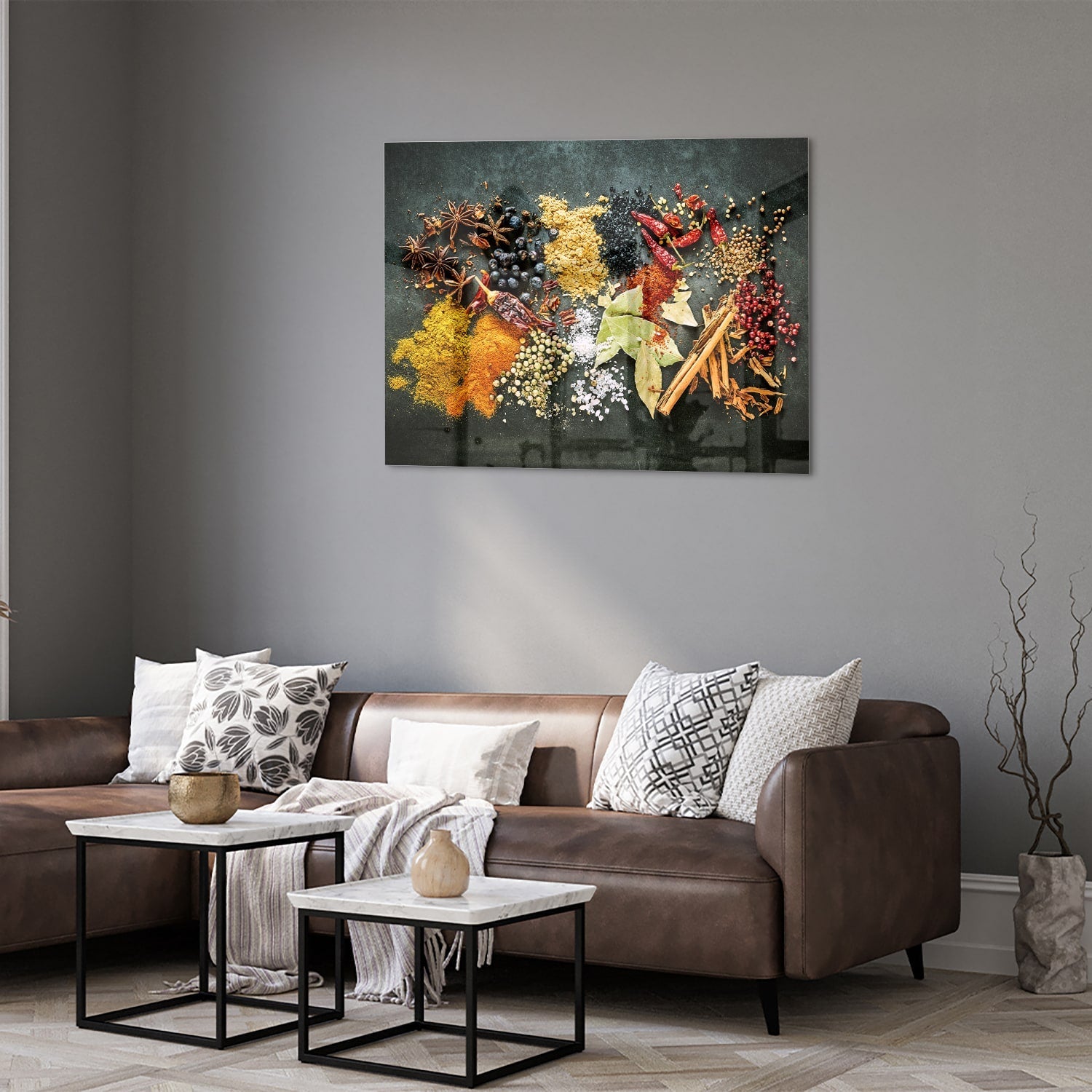 Glazen schilderij met een kleurrijke compositie van specerijen en bladeren in een moderne woonkamer.