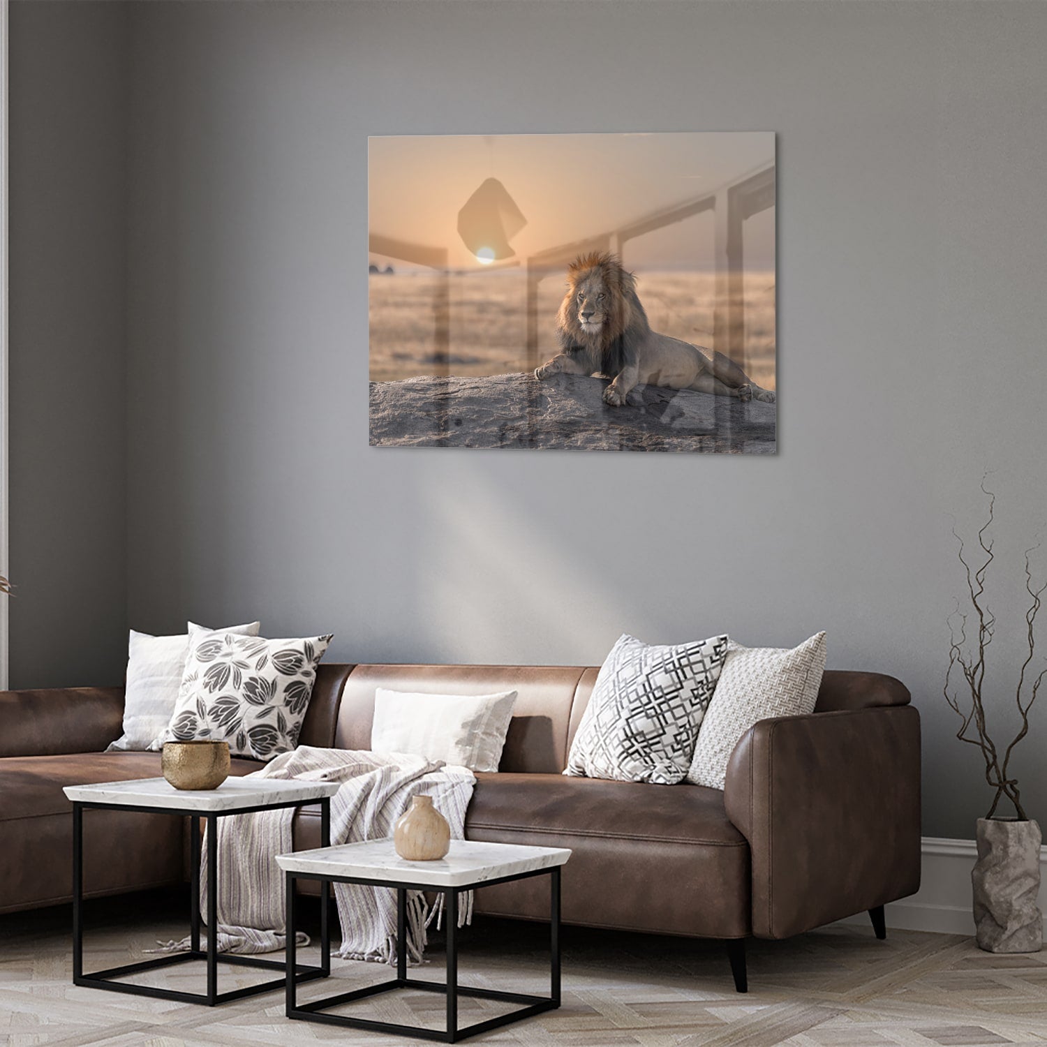 Glazen schilderij van een leeuw die op een rots ligt met zonsondergang op de achtergrond.