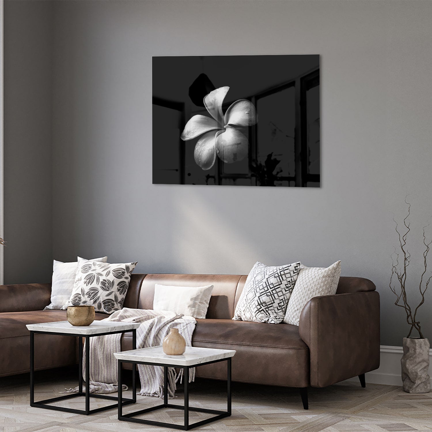 Zwart glazen schilderij met bloemmotief boven een houten kast in een lichte kamer.