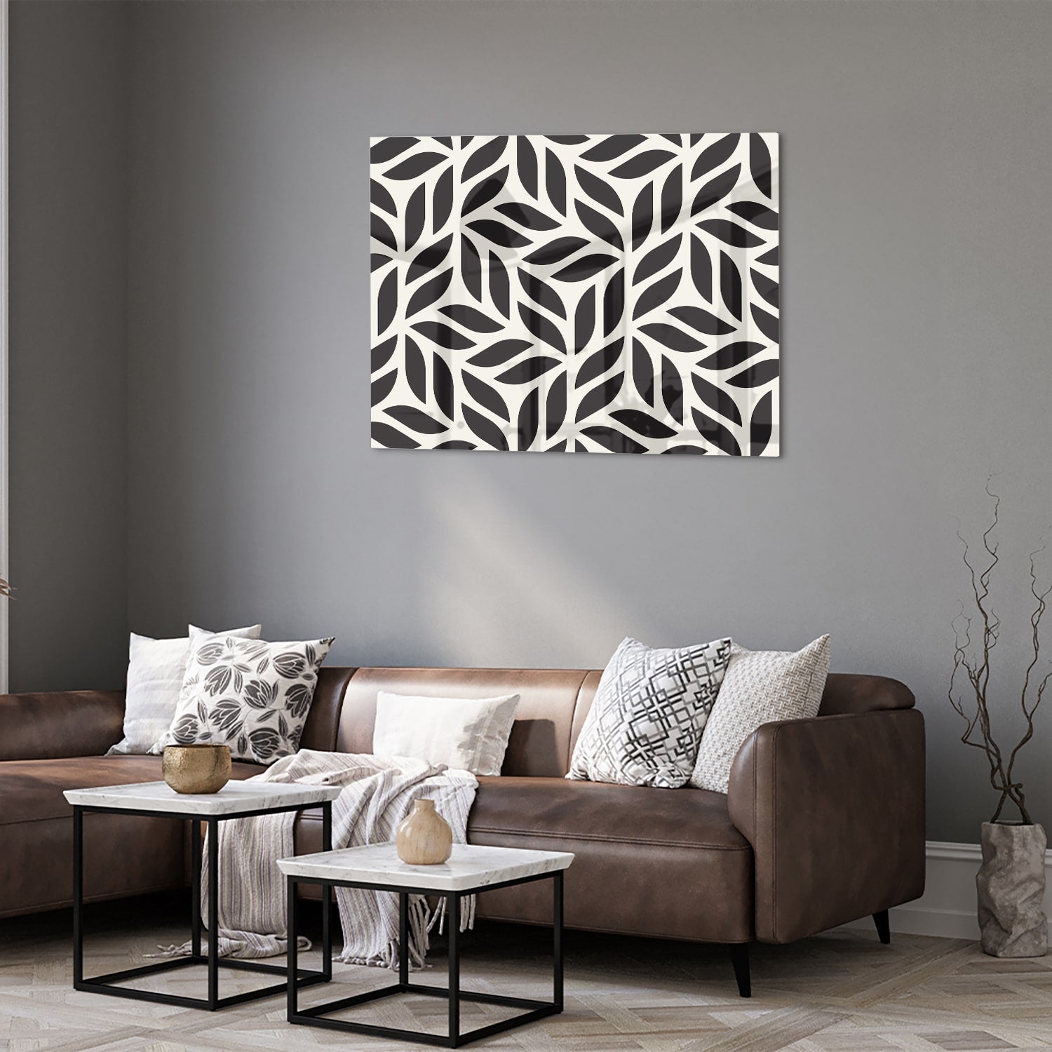 Zwart-wit glazen schilderij met bladerenpatroon aan de muur in een moderne woonkamer.