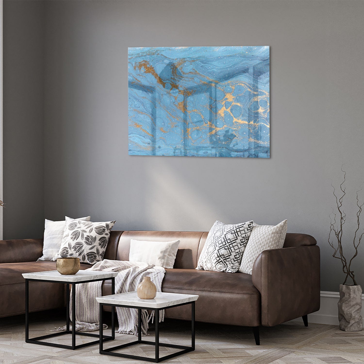 Glazen schilderij met blauw en gouden patronen aan de muur boven een houten kast.