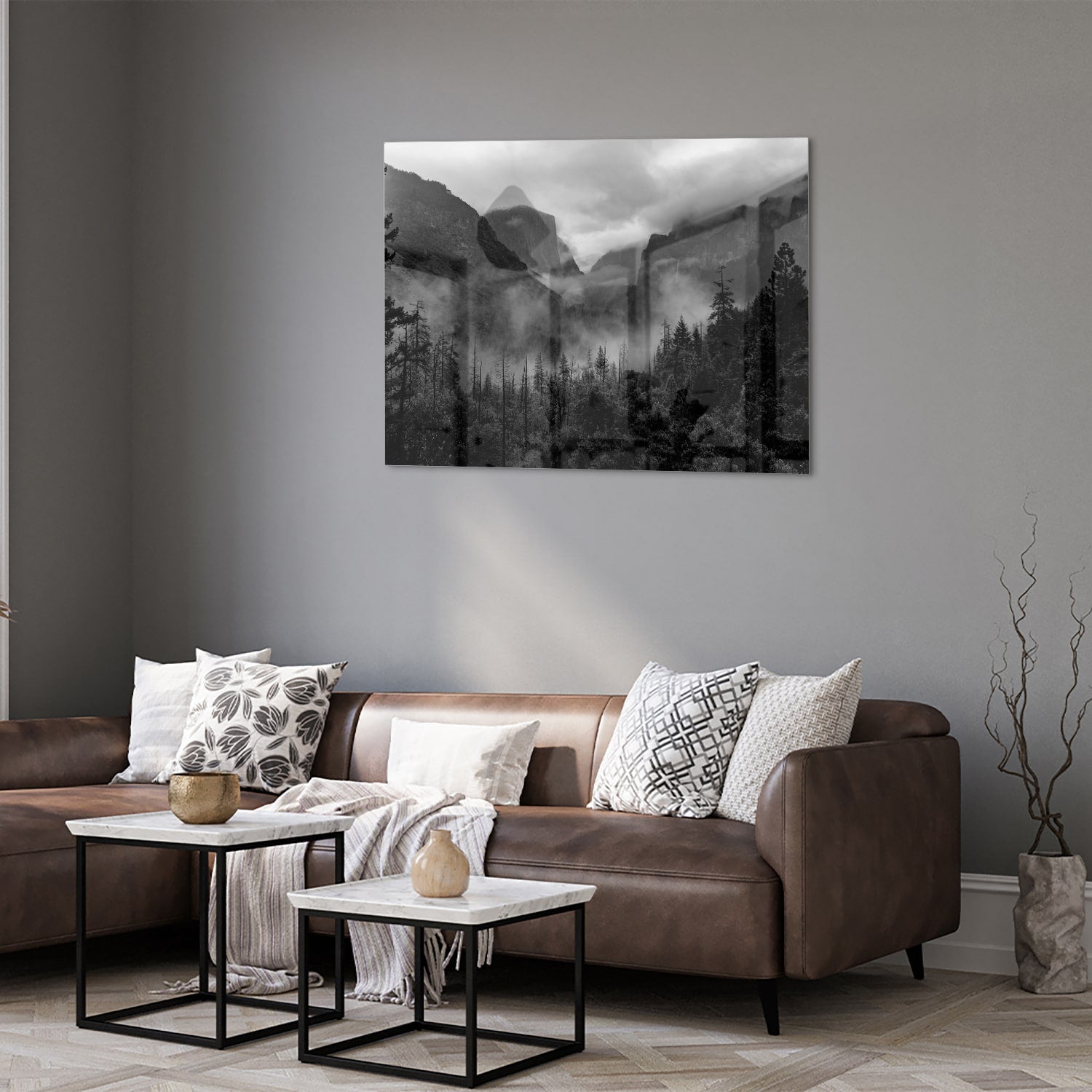 Zwart-wit glazen schilderij van een sereen berglandschap aan de muur.
