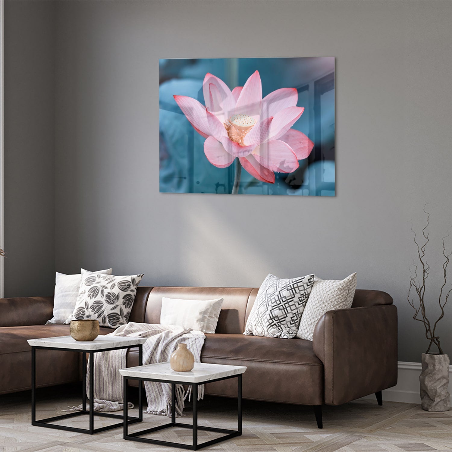 Glazen schilderij van een roze lotus boven een houten meubelstuk in een gezellige woonkamer.
