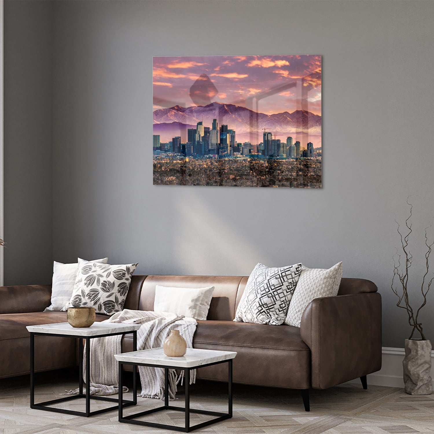Glazen schilderij van een stadspanorama bij zonsondergang met bergen op de achtergrond.