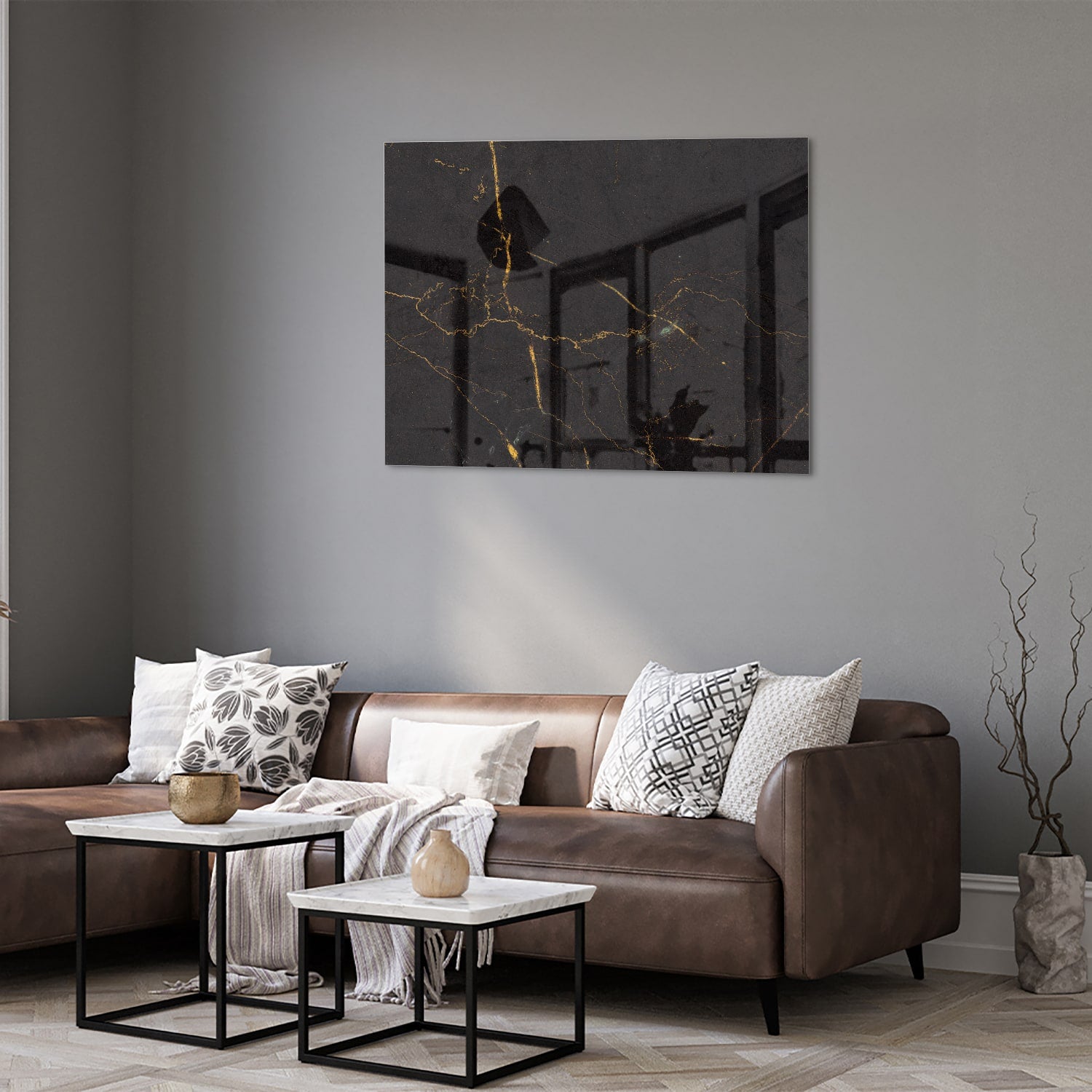 Zwart glazen schilderij met gouden lijnen aan de muur in een moderne woonkamer.