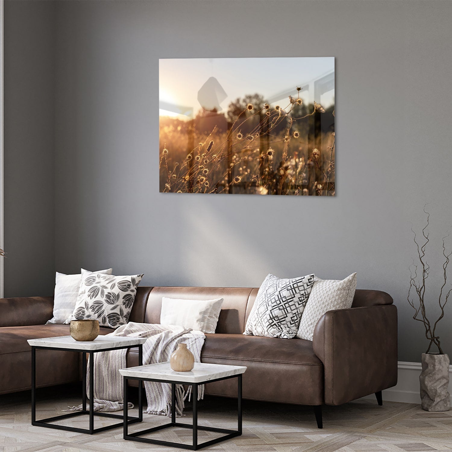 Glazen schilderij van een zonsondergang met bloeiende bloemen, hangend aan een witte muur.