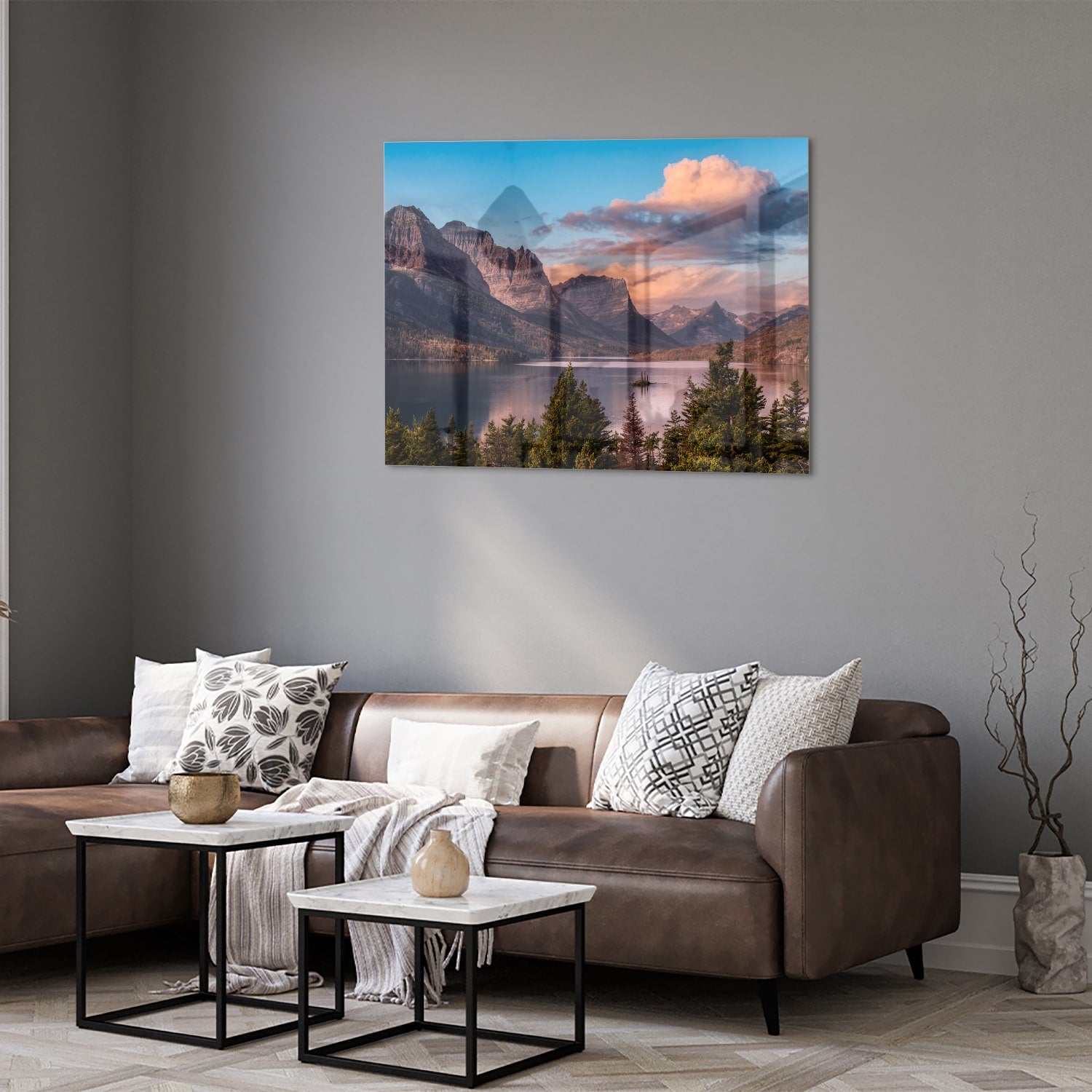 Glazen schilderij van bergen bij zonsopgang in een lichte woonkamer.
