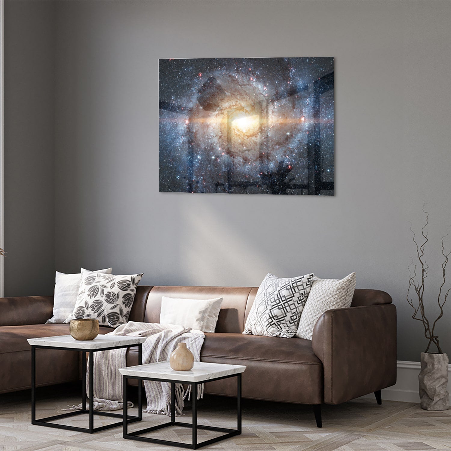 Glazen schilderij van een sterrenstelsel aan de muur in een lichte woonkamer.
