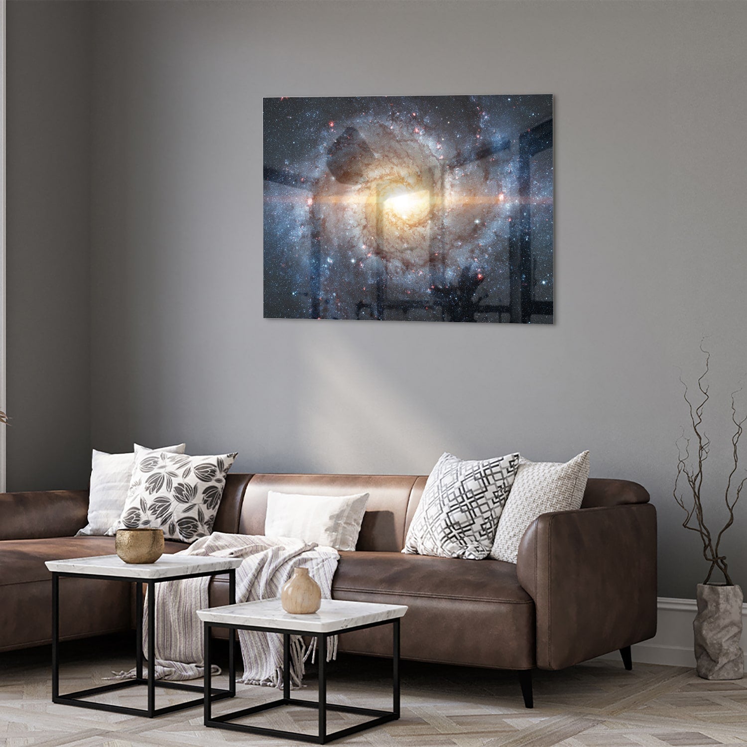 Glazen schilderij van een sterrenstelsel aan de muur in een lichte woonkamer.