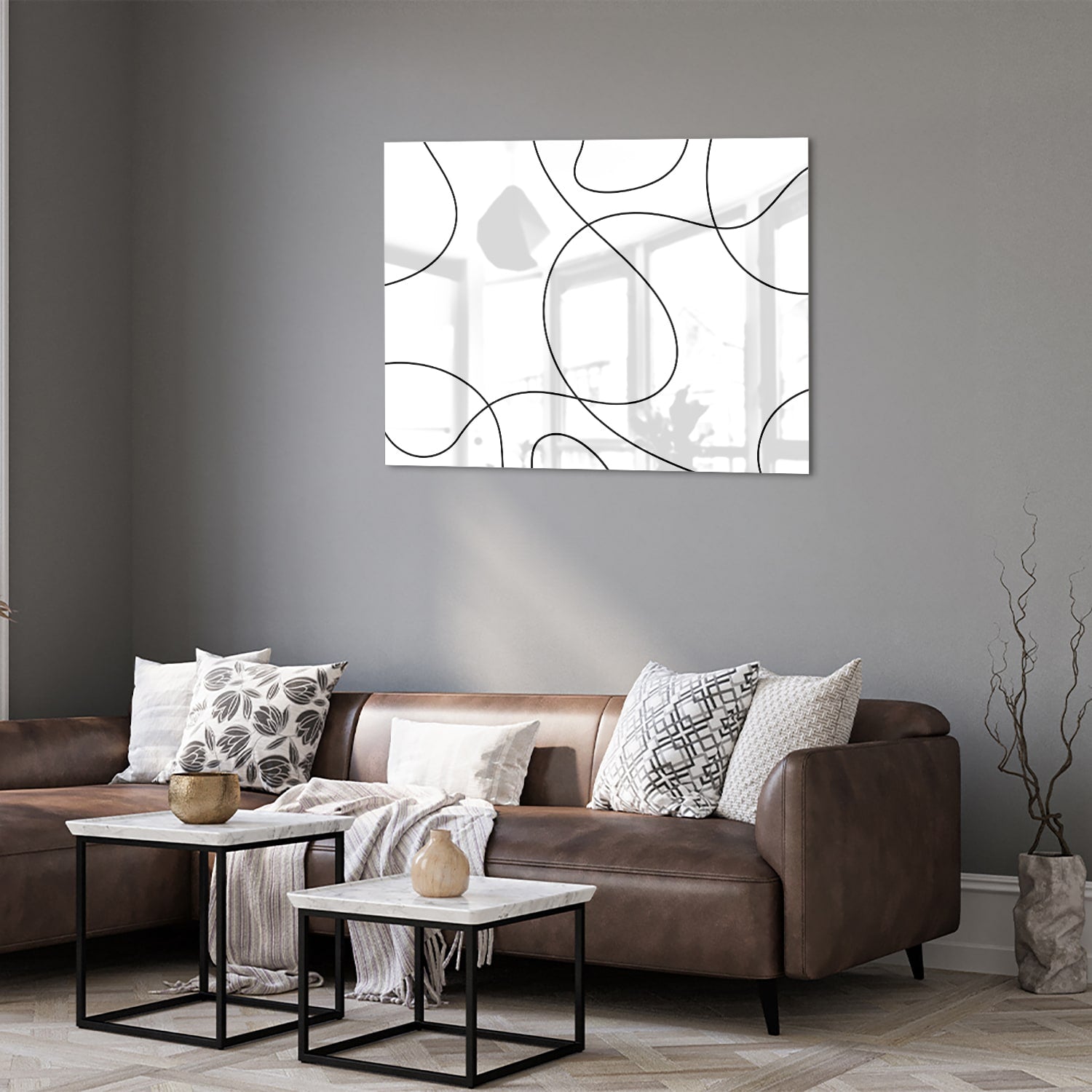 Glazen schilderij met elegante zwarte lijnen in een moderne woonkamer.