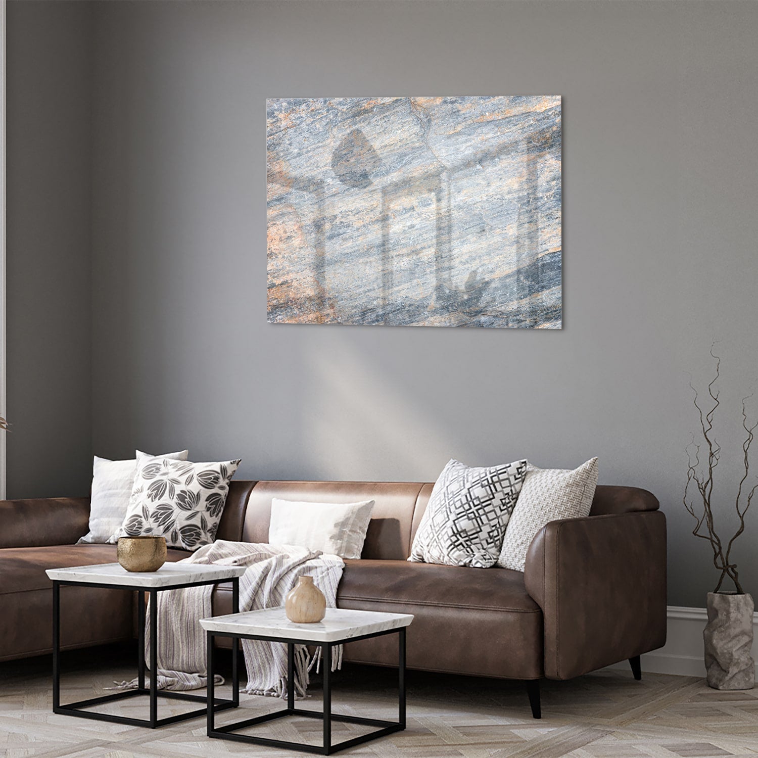 Abstract glazen schilderij met blauwe en oranje tinten aan de muur in een moderne woonkamer.