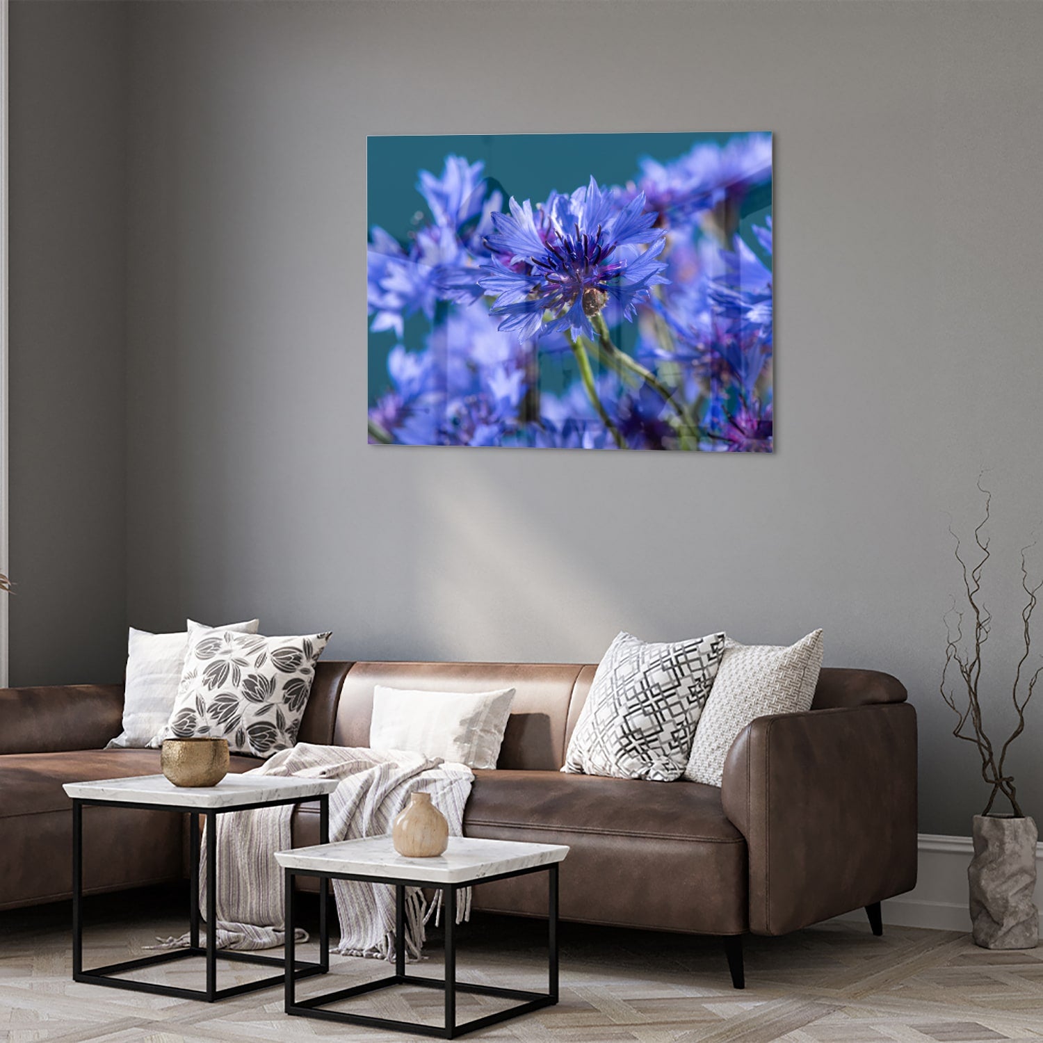 Een glazen schilderij met paarse bloemen op een witte muur, in een sfeervolle woonkamer.