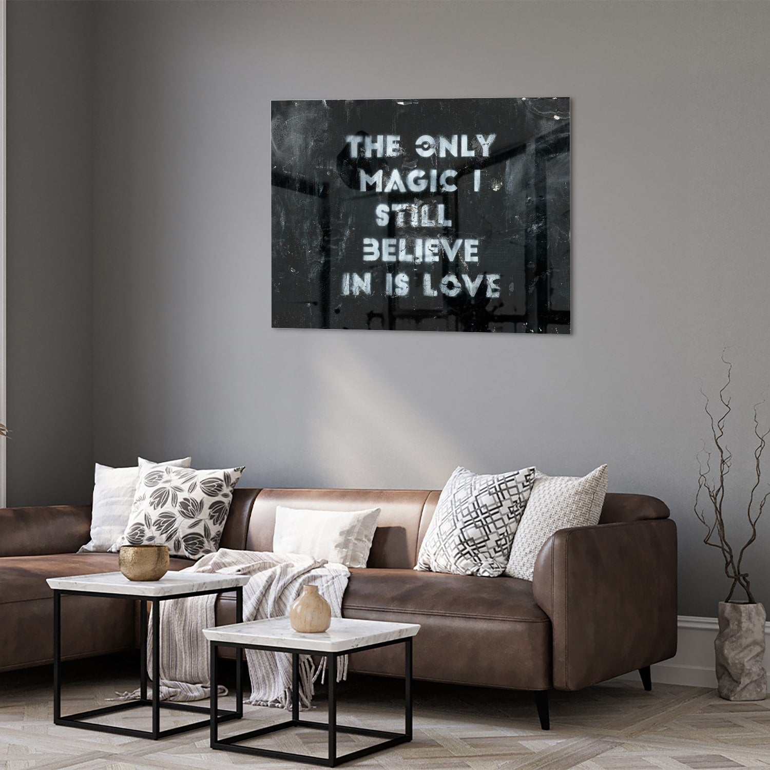 Glazen schilderij met de tekst 'The only magic I still believe in is love', hangt aan de muur in een lichte woonkamer.