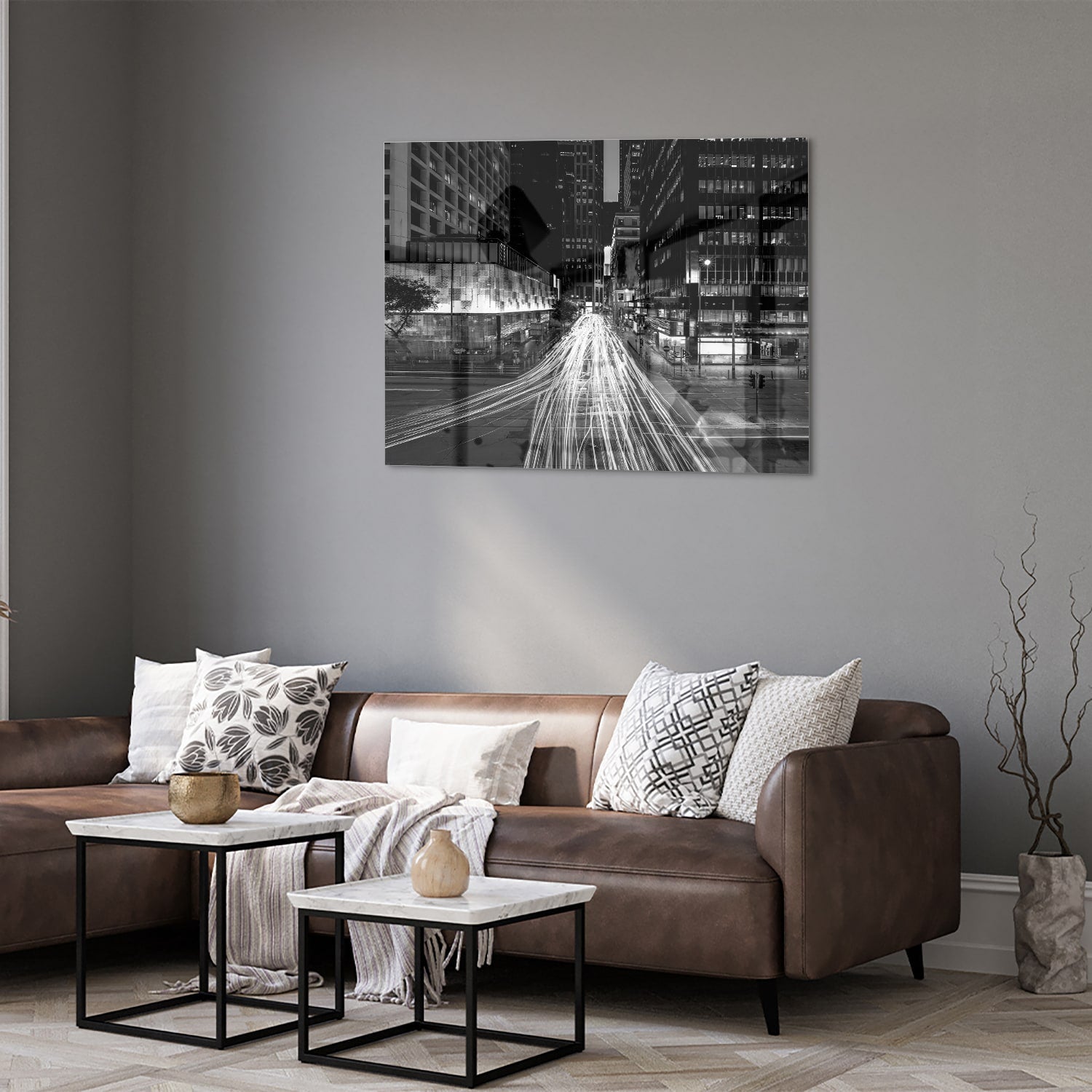 Glazen schilderij met stadslichten in zwart-wit boven een moderne meubelset.