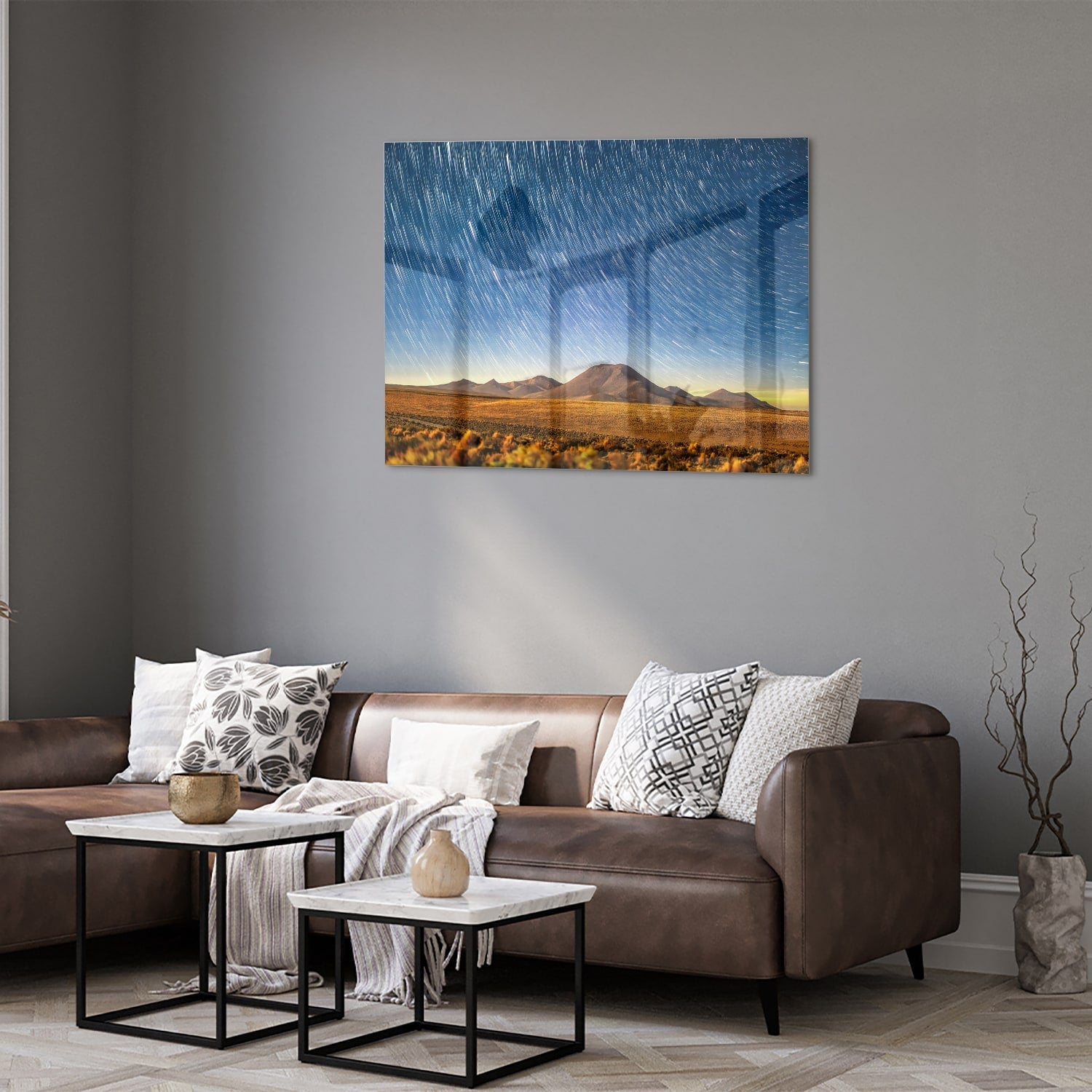 Glazen schilderij met sterrenhemel boven bergen, hangend aan de muur.