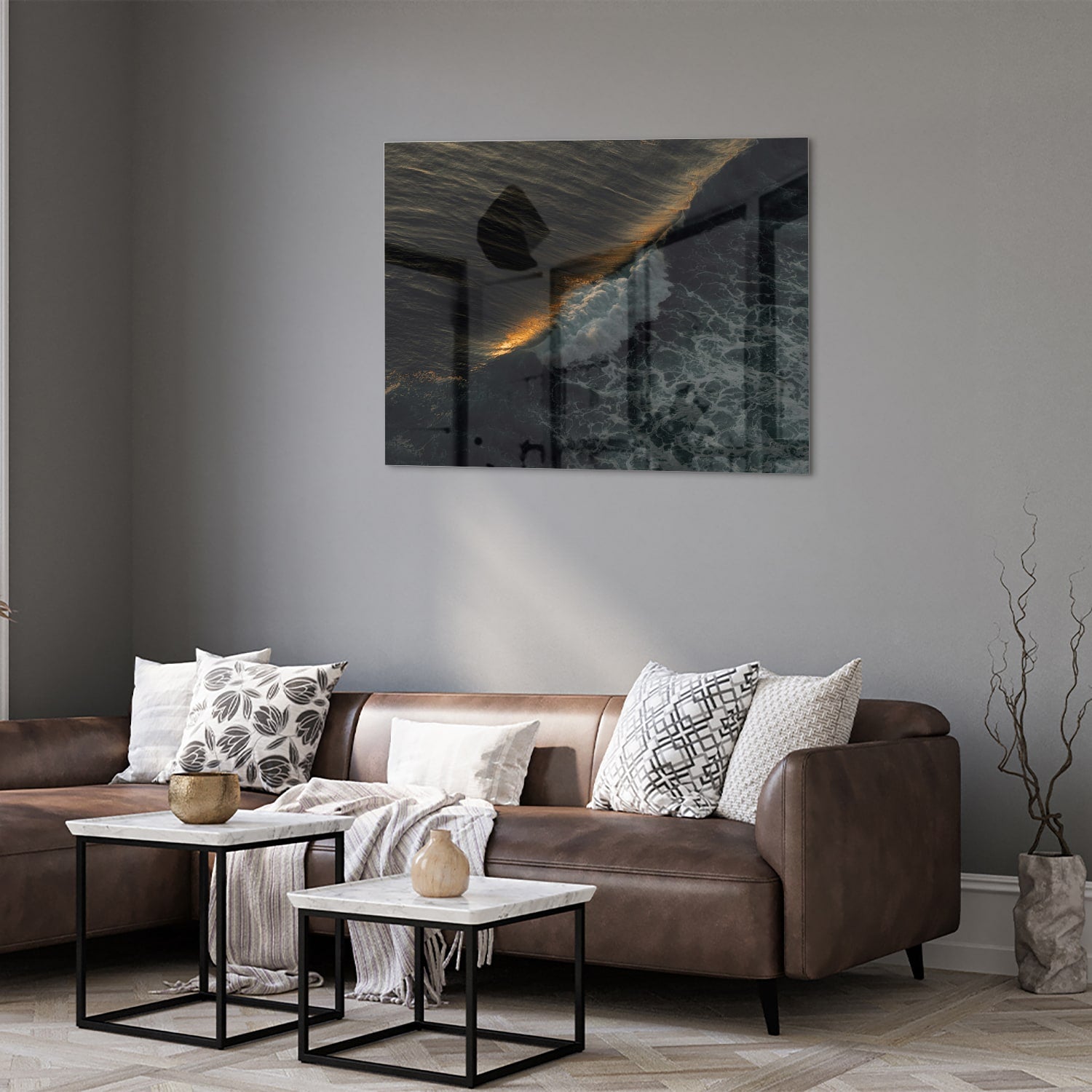 Zwart glazen schilderij van een zeegezicht met gouden accenten, hangt aan een lichtgekleurde muur.