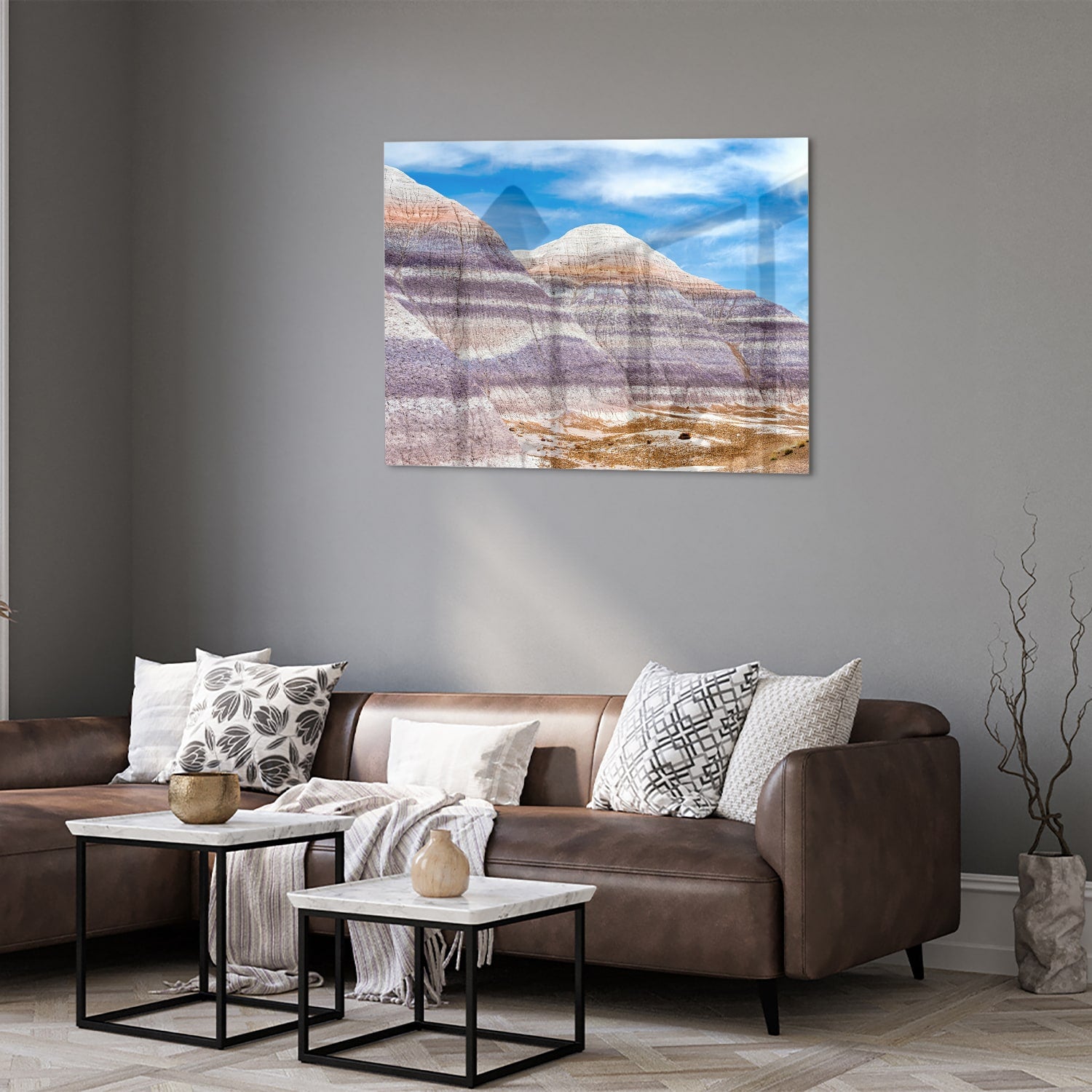 Glazen schilderij van bergen met een blauwe lucht in een moderne woonkamer.